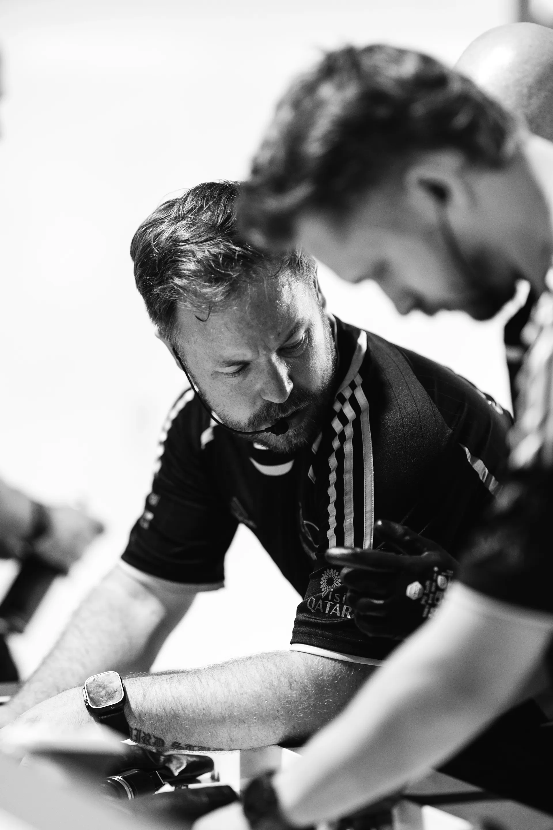 Audi Revolut F1® Team engineer studies data while discussing with a colleague during garage operations.