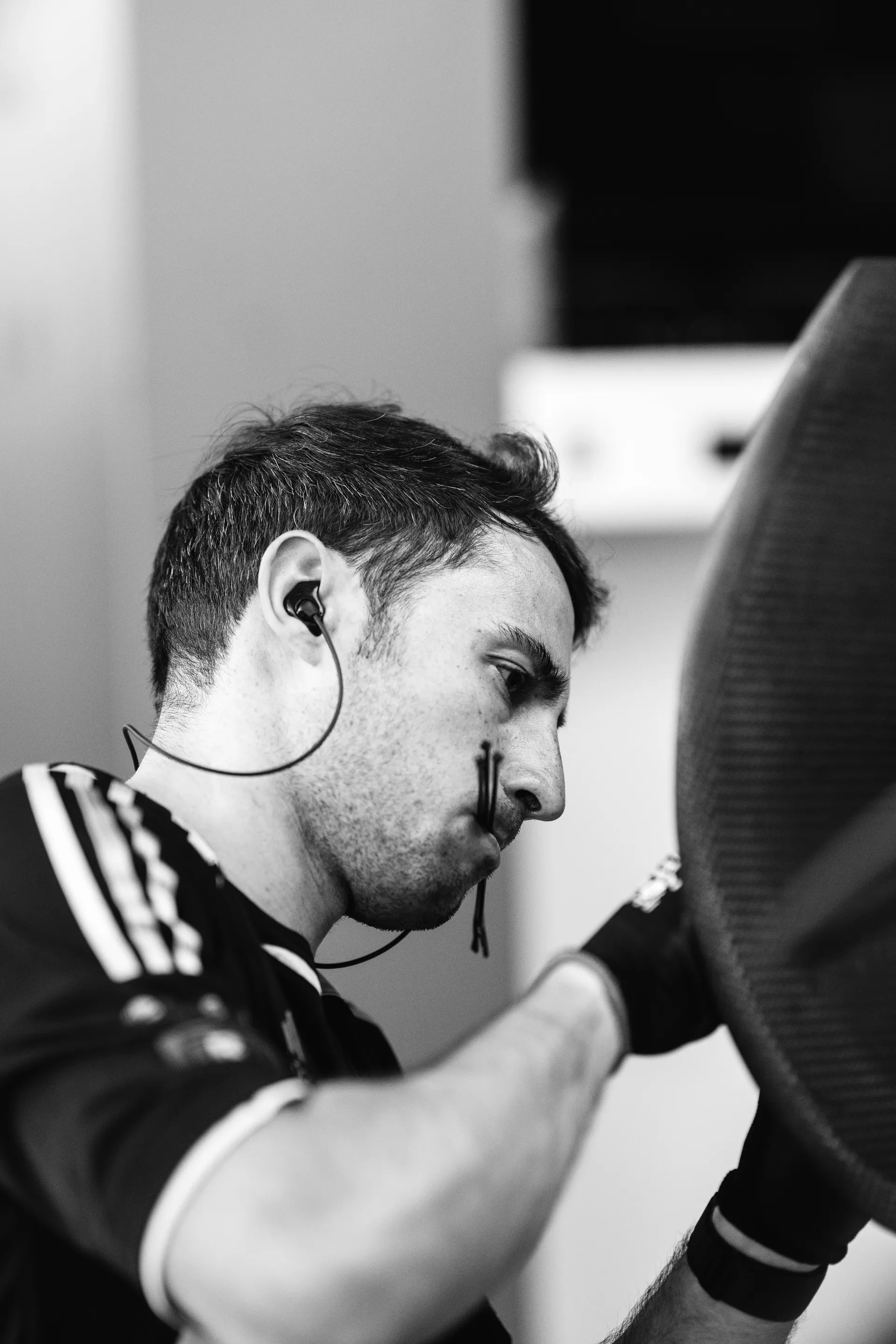 Audi Revolut F1® Team mechanic works closely on a car component, wearing gloves and in-ear communication.