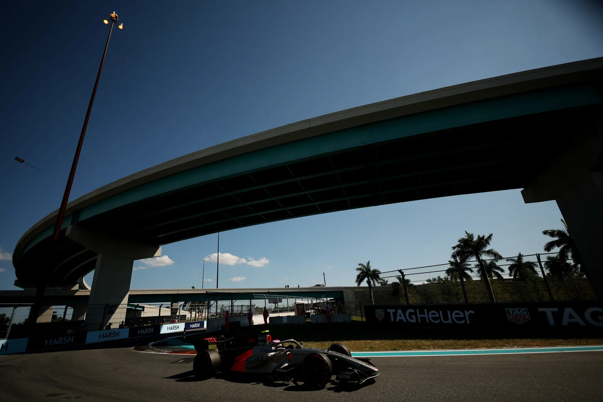 Audi Revolut F1® Team car driving under highway bridge at Miami Grand Prix circuit