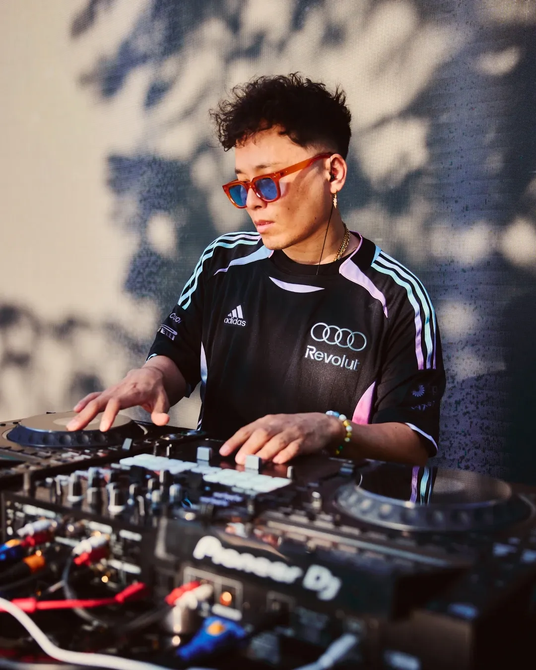 DJ wearing Audi Revolut F1® Team apparel performing on stage with mixing equipment during the off-track activation