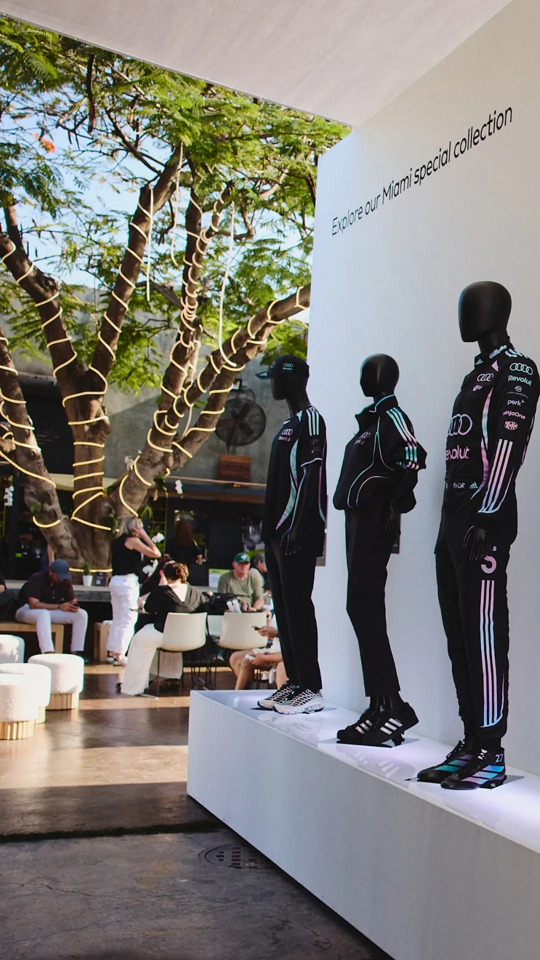 Display of Audi Revolut F1® Team Miami special collection on mannequins in an outdoor lounge setting