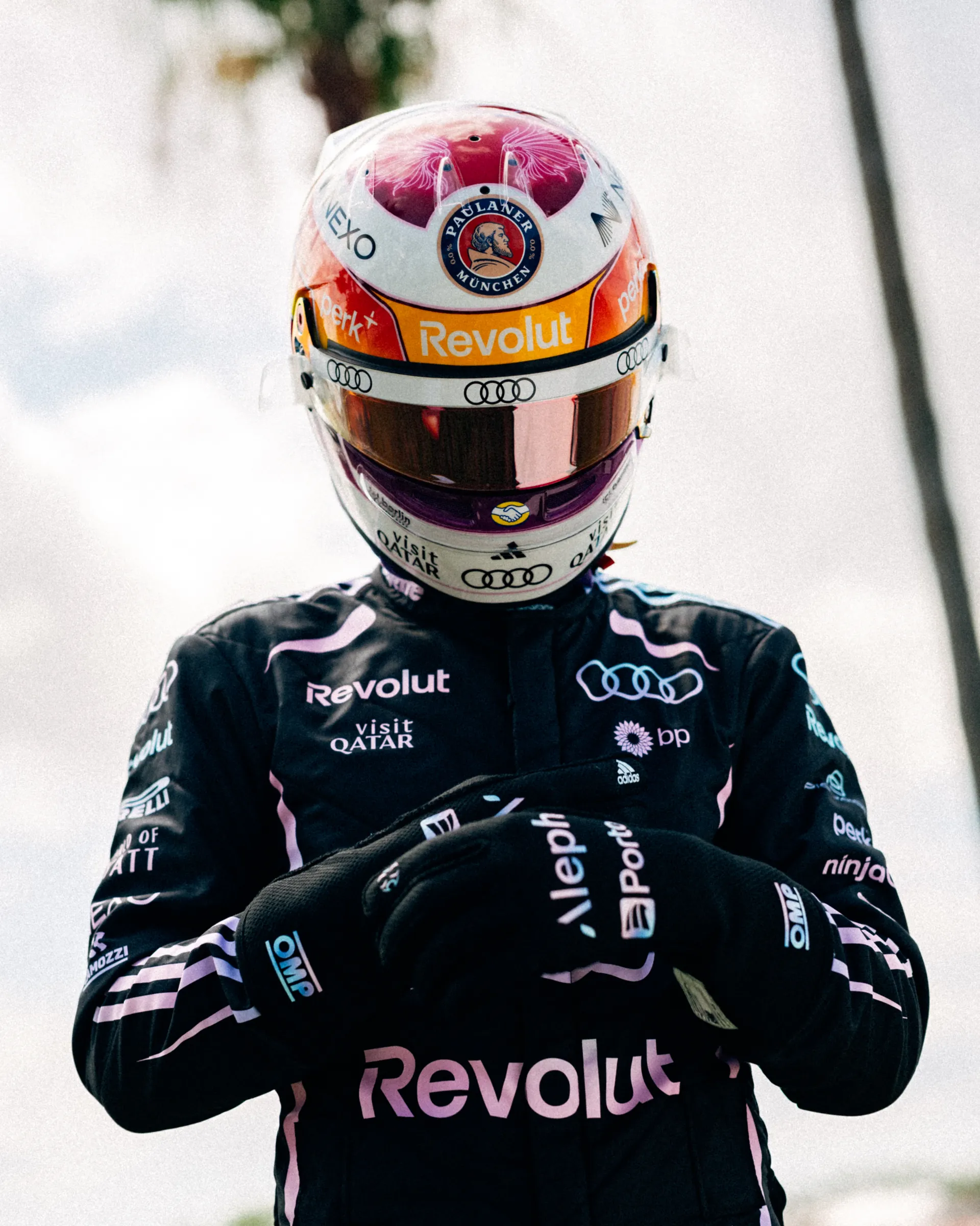 Gabriel Bortoleto wearing his special Miami edition race helmet and Audi Revolut F1® Team Miami race suit, arms crossed in a confident pose.