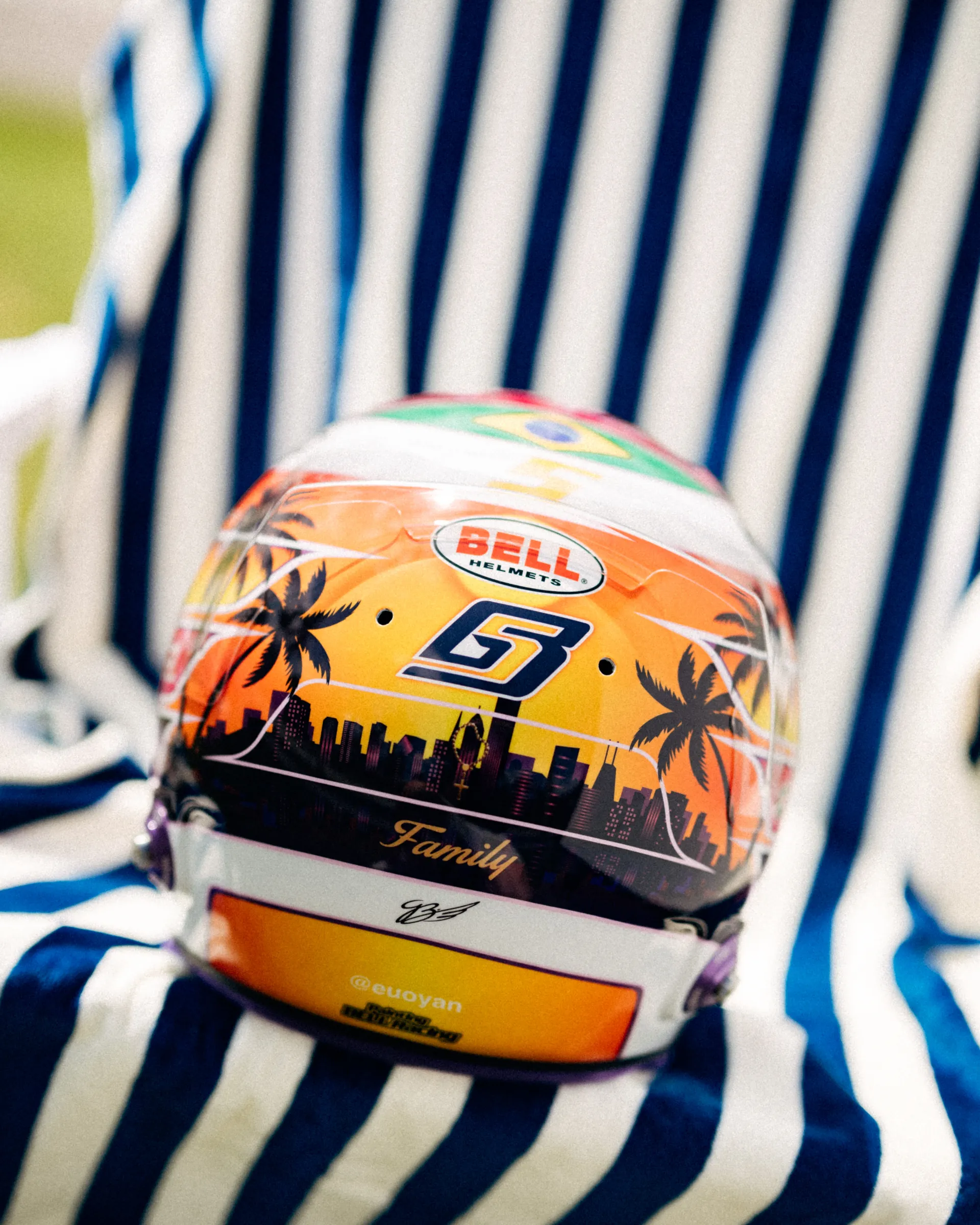 Rear view of Gabriel Bortoleto’s special Miami edition race helmet on a striped beach chair, featuring a Miami skyline, palm trees, and the number 5.