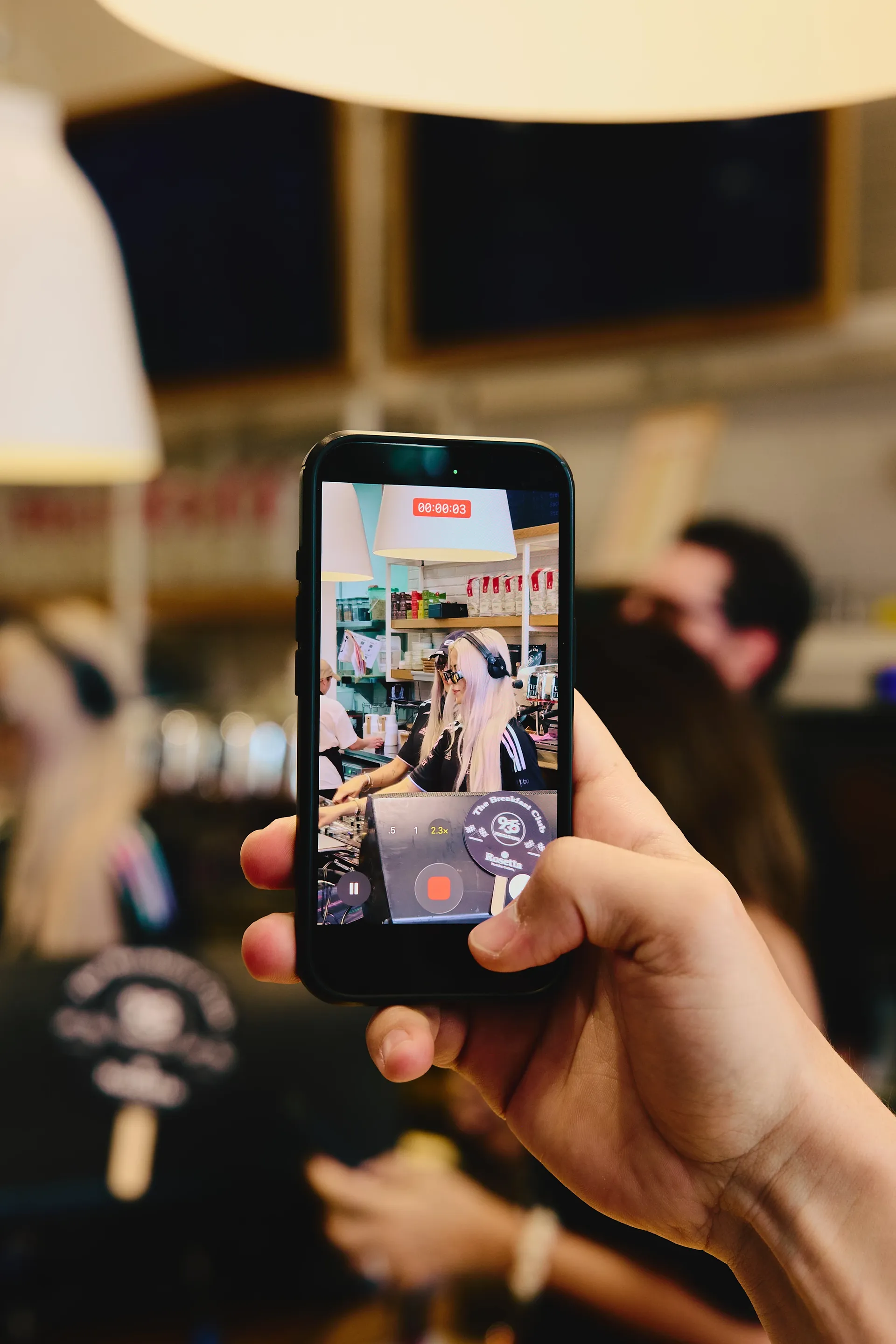 Close-up of a smartphone recording a DJ set at the Audi Revolut F1® Team activation, capturing live content creation and fan engagement.