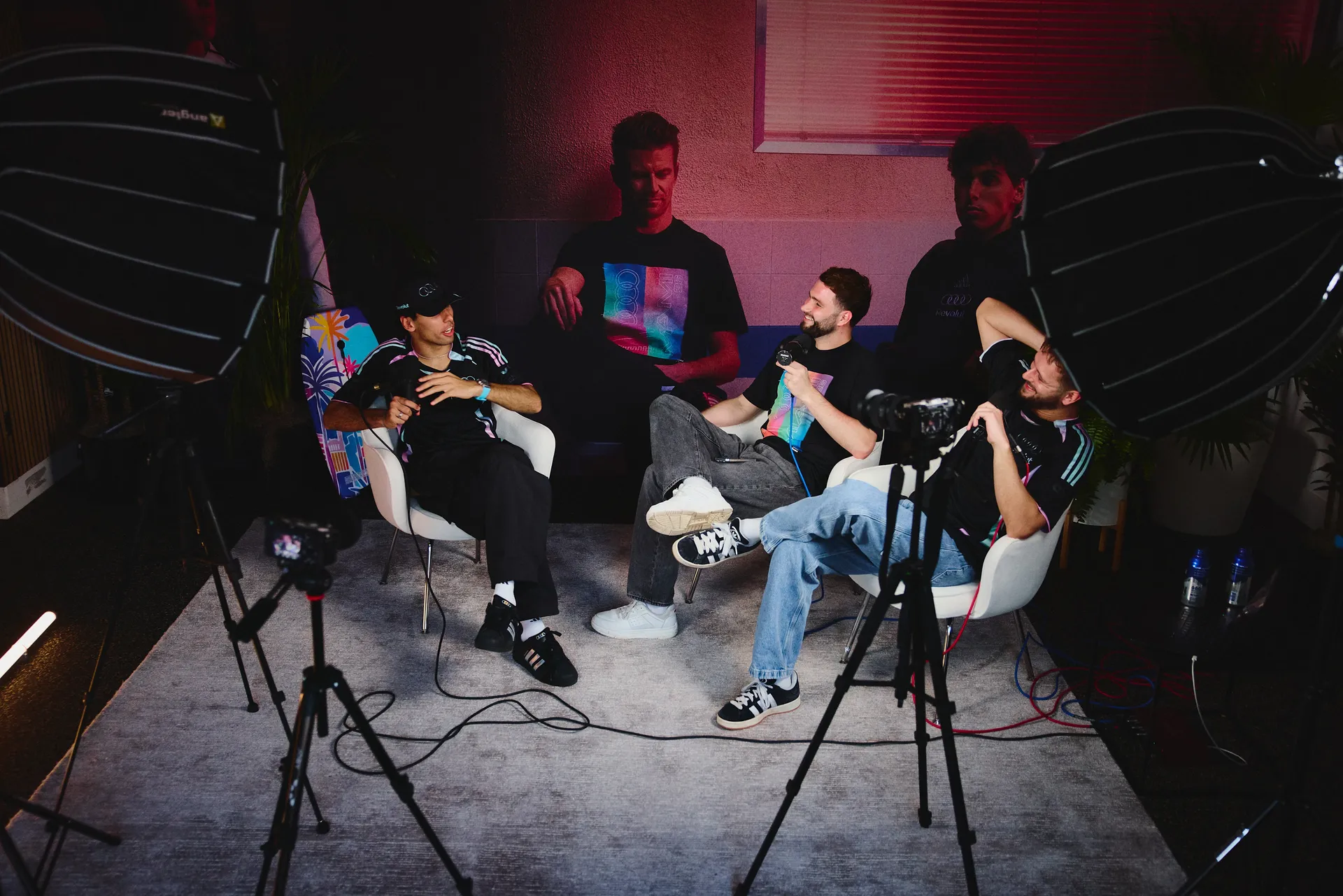 Studio setup with three men recording a podcast or interview, featuring Audi Revolut F1® Team apparel and professional lighting equipment.