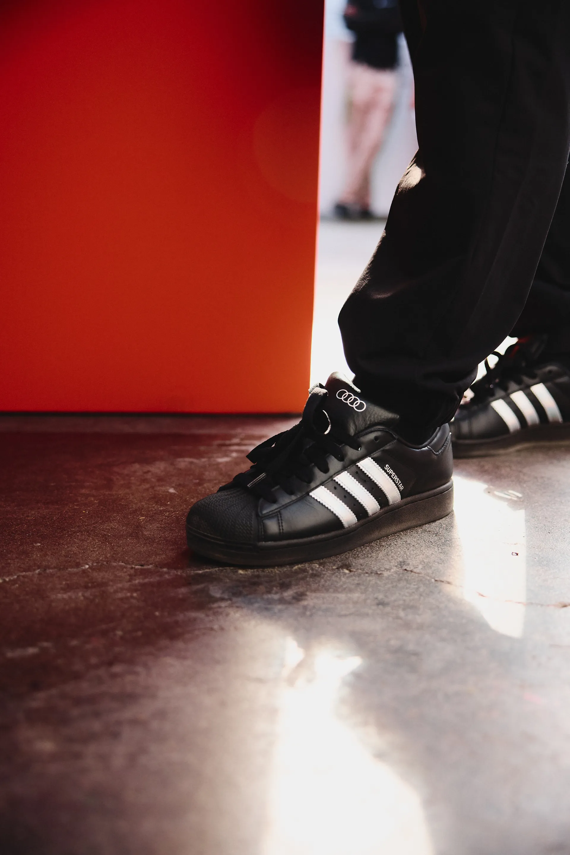 Close-up of black adidas sneakers with Audi branding worn at the activation, highlighting product detail and lifestyle integration.