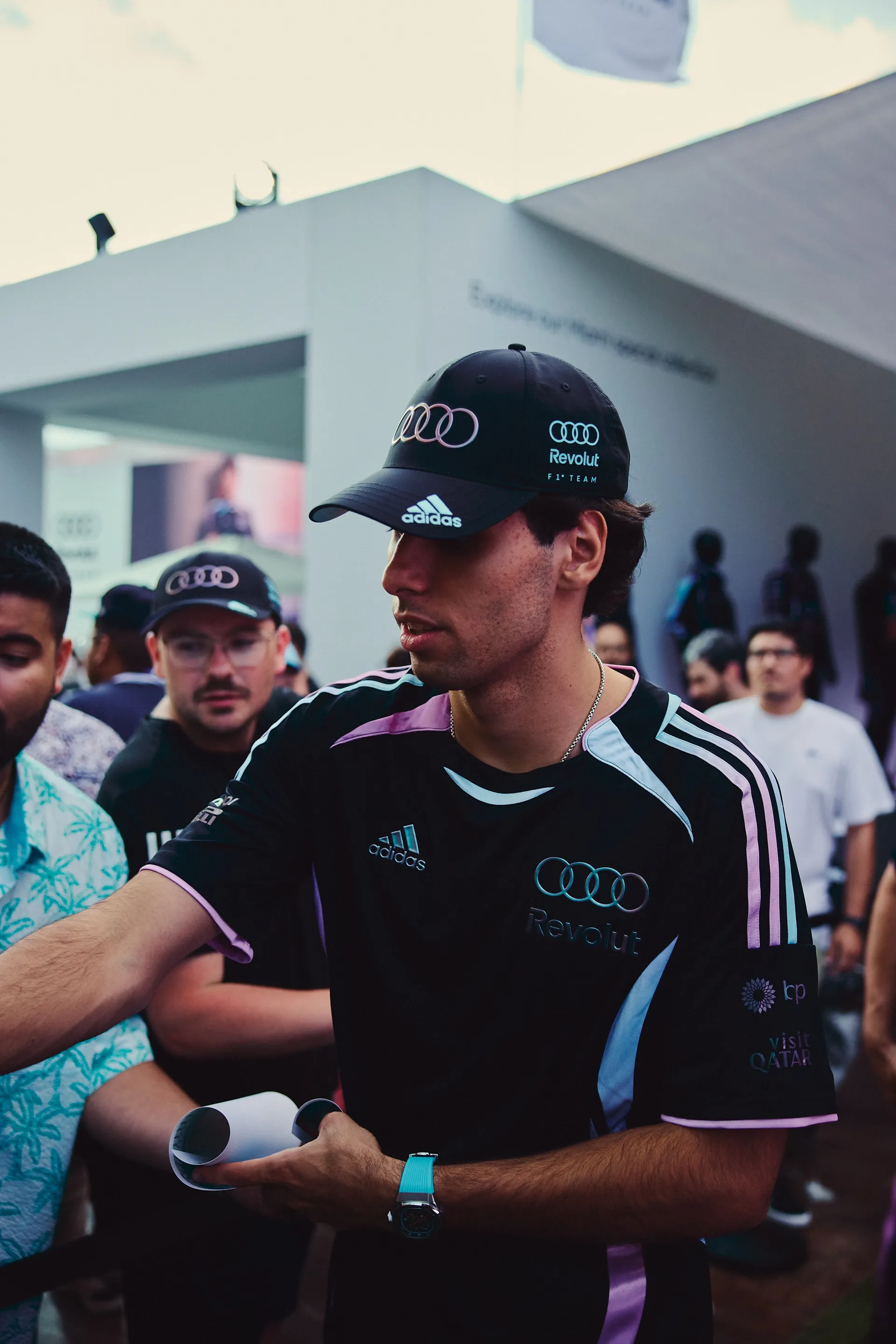 Audi Revolut F1® Team driver interacts with fans during autograph session, surrounded by a diverse and engaged audience.