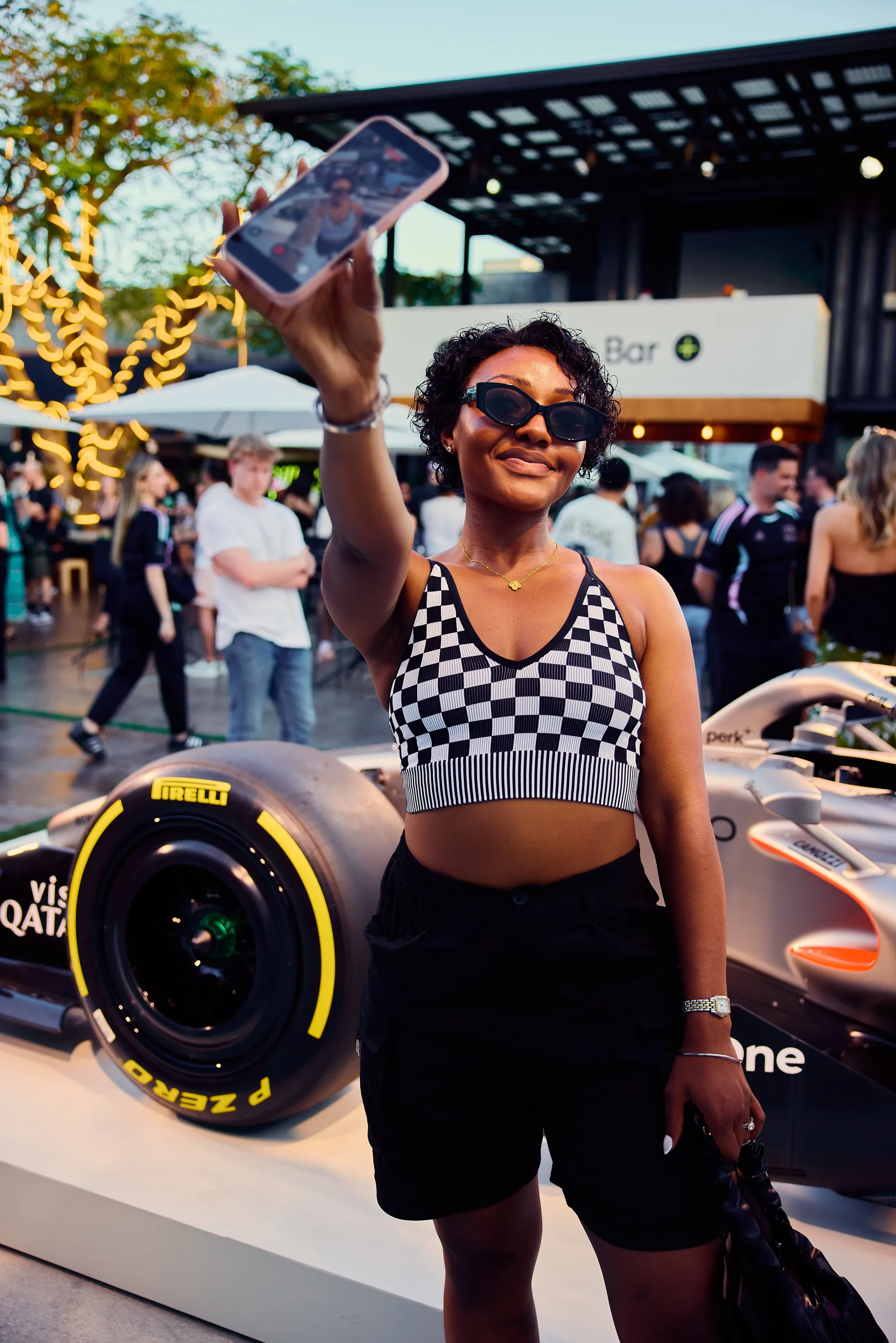 Female fan taking a selfie in front of an Audi Formula 1 show car, capturing lifestyle and social sharing moment.