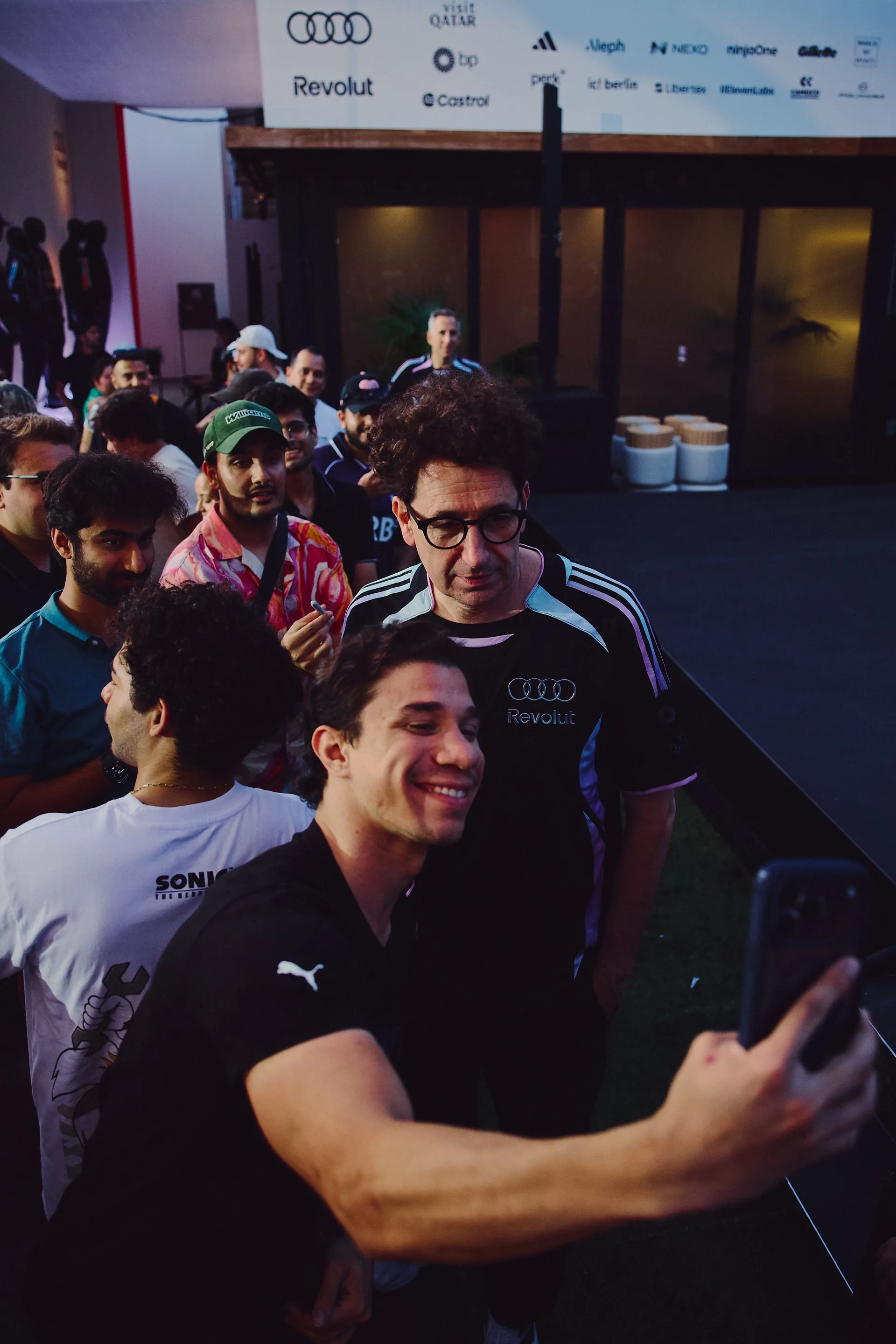 Fans taking selfies with Mattia Binorto at the Audi Revolut F1® Team activation space, emphasizing community and social interaction.