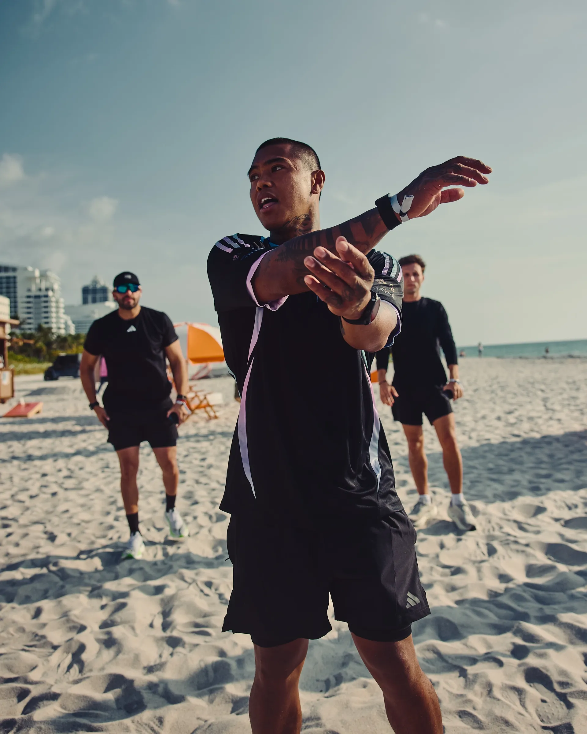 Group fitness activity on Miami beach featuring Audi Revolut F1® Team apparel, blending sport, lifestyle, and coastal environment.