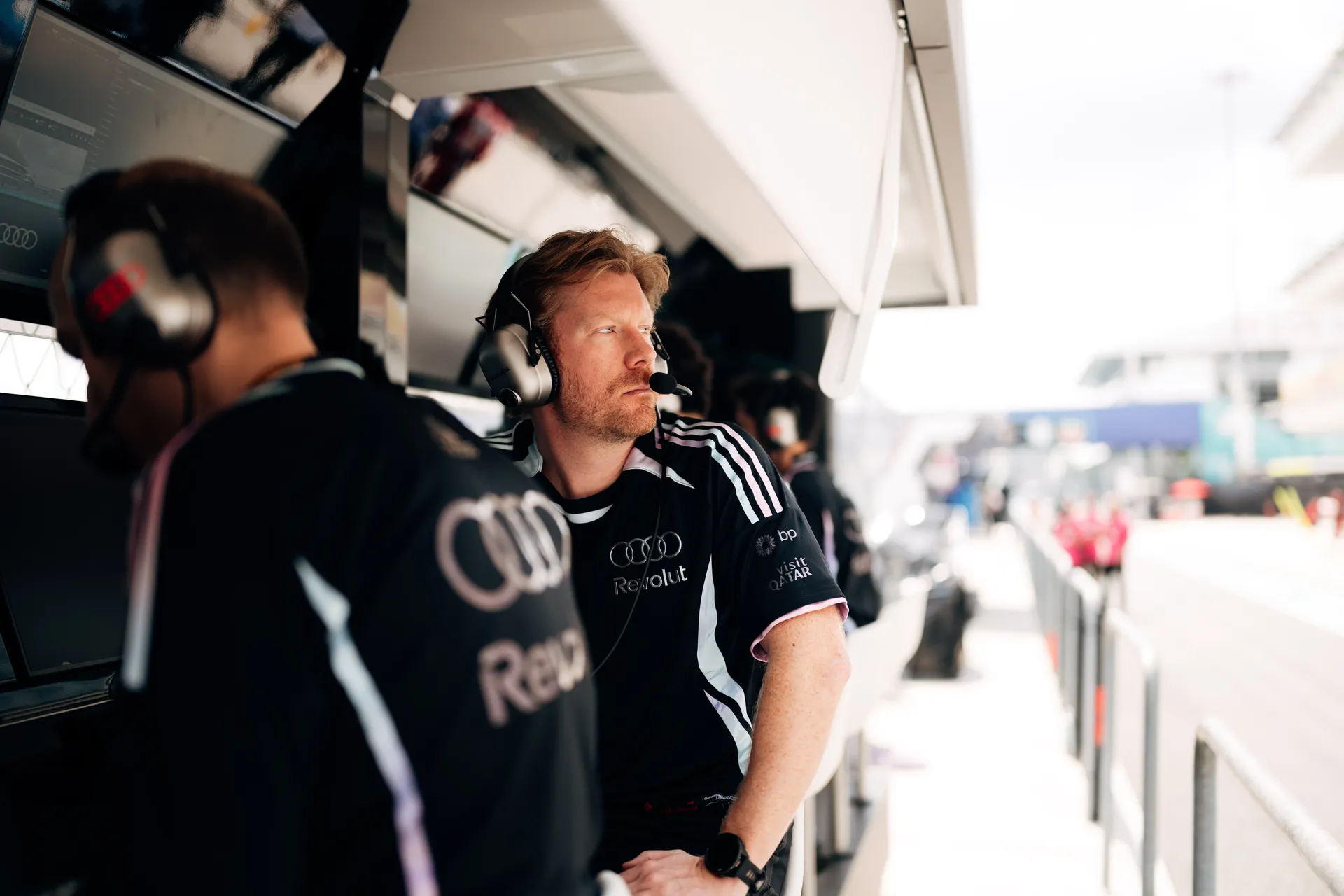 Audi Revolut F1® Team pit wall engineer wearing a headset looking out toward the track during a session