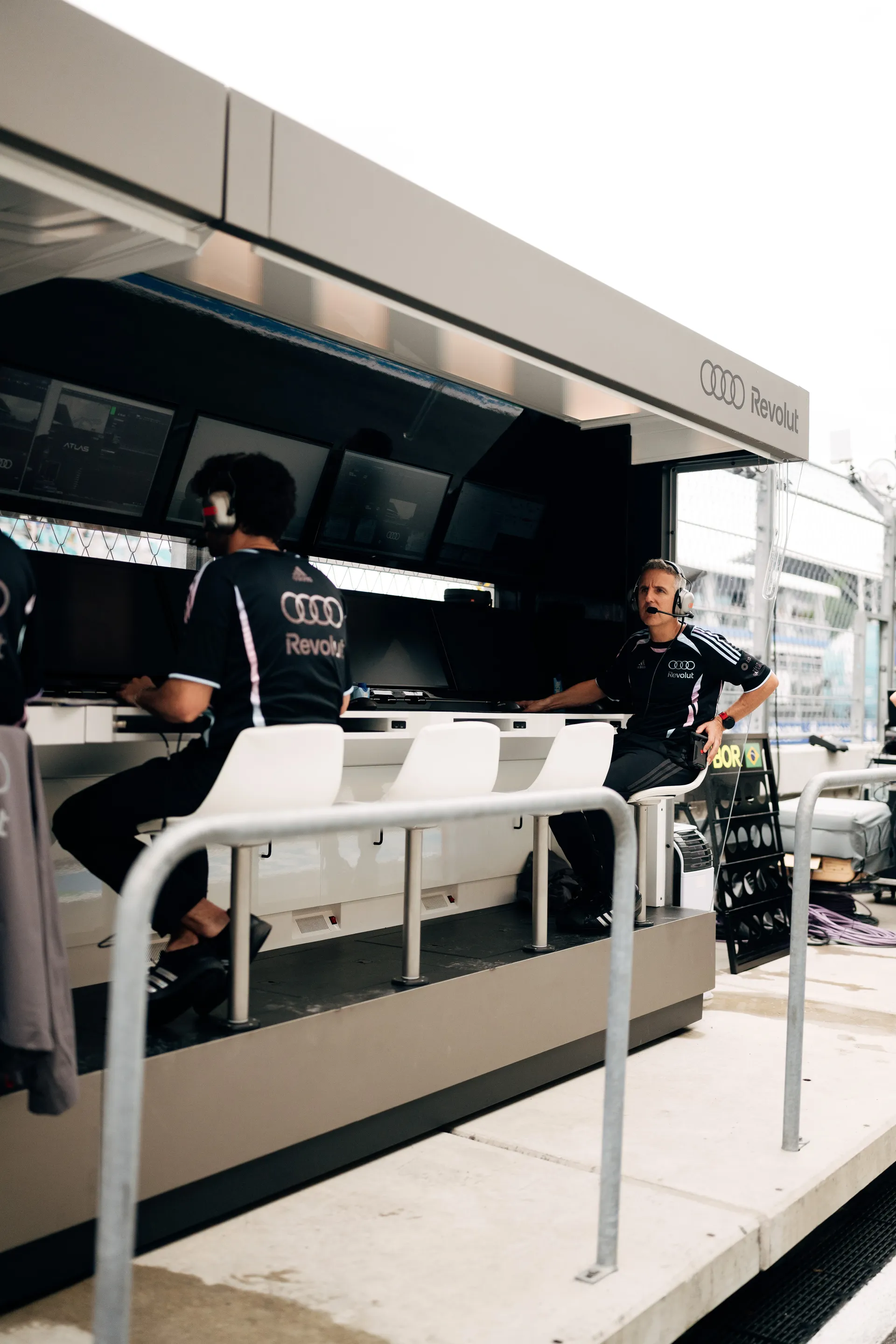 Audi Revolut F1® Team pit wall setup with engineers seated at monitors, analyzing data and communicating during the Miami Grand Prix weekend.