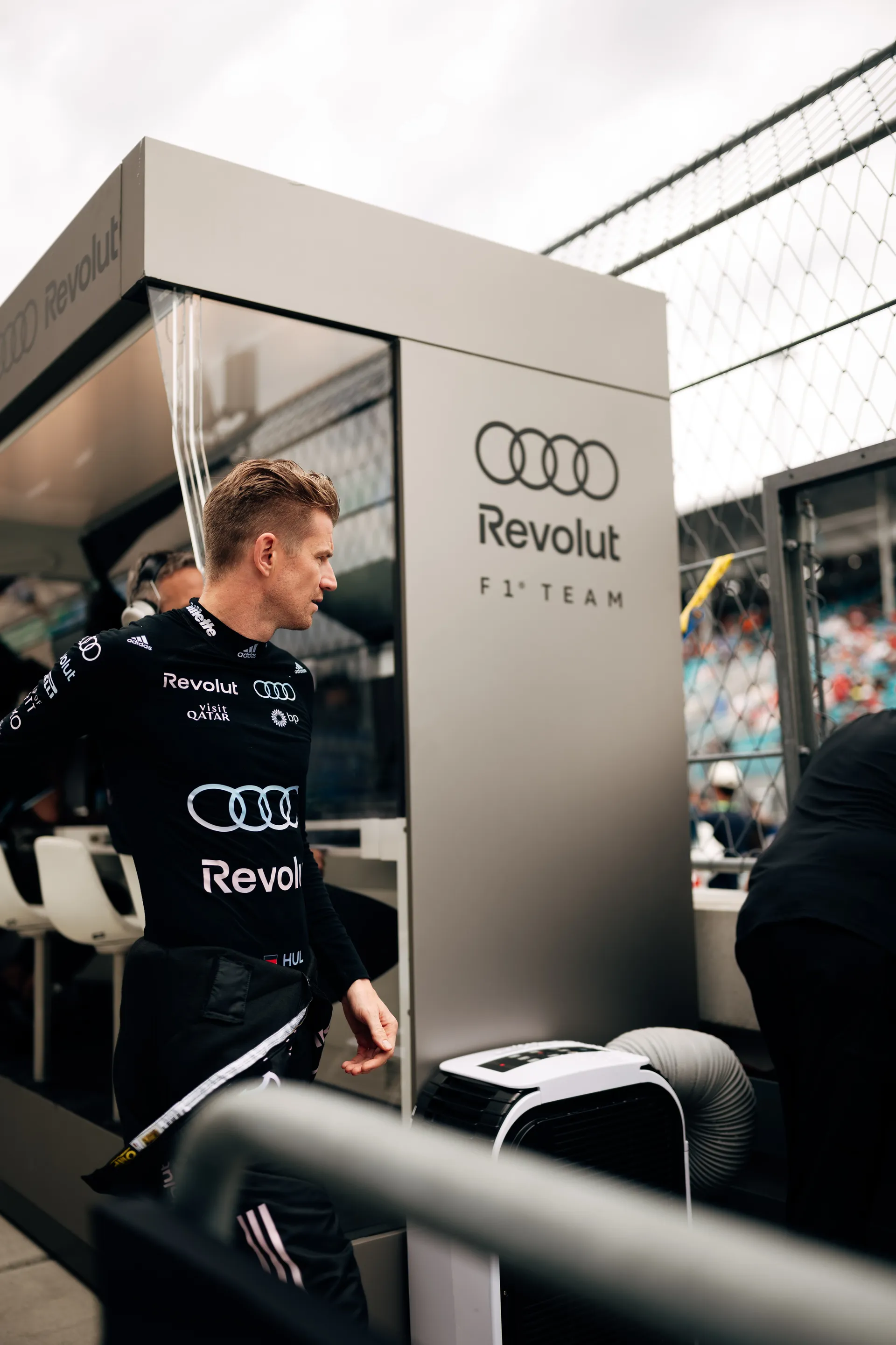 Nico Hulkenberg standing trackside at the Audi Revolut F1® Team pit wall, looking toward the circuit.