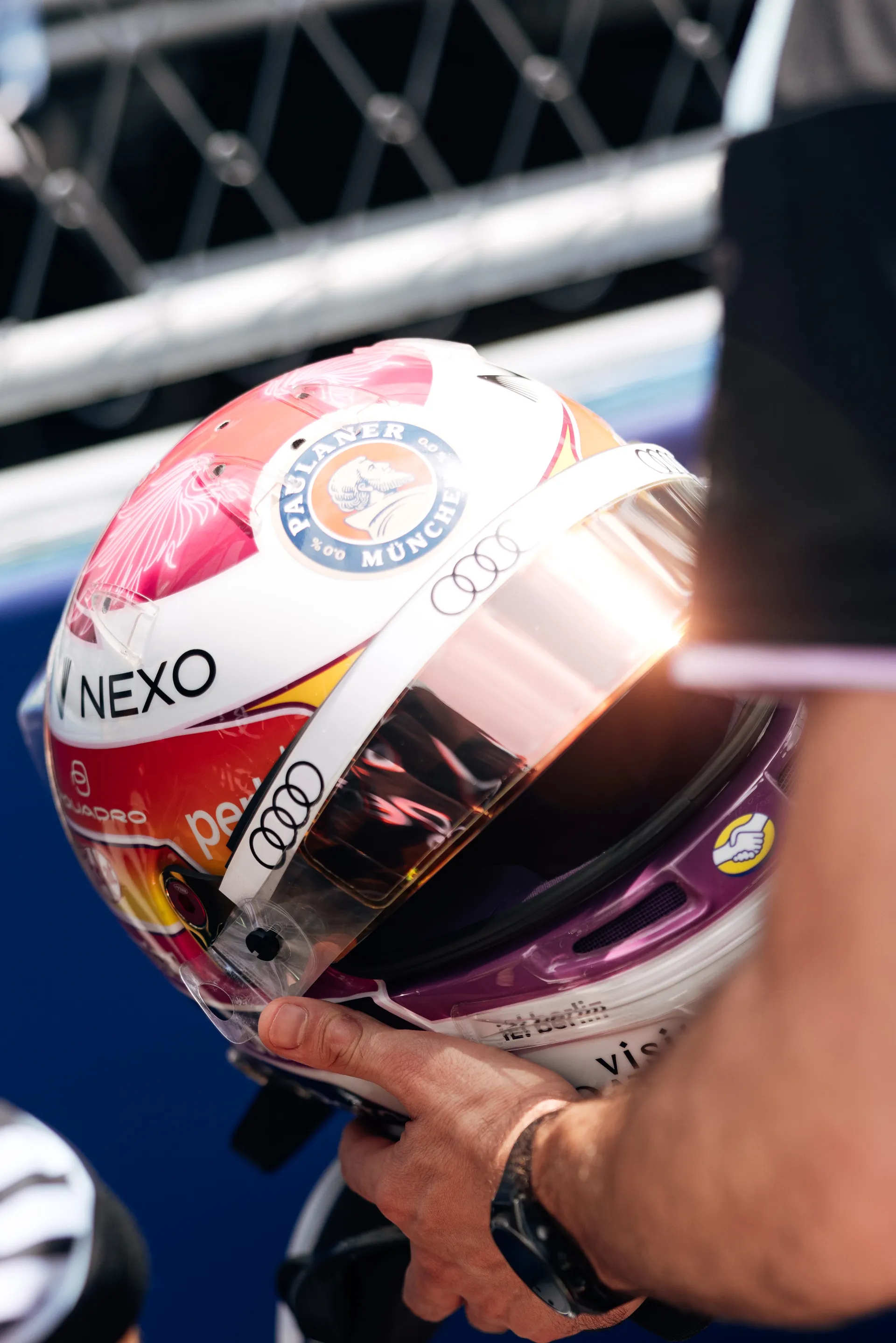 Close up of Gabriel Bortoleto’s Miami helmet being held in hand, showing its colorful design and reflective visor.