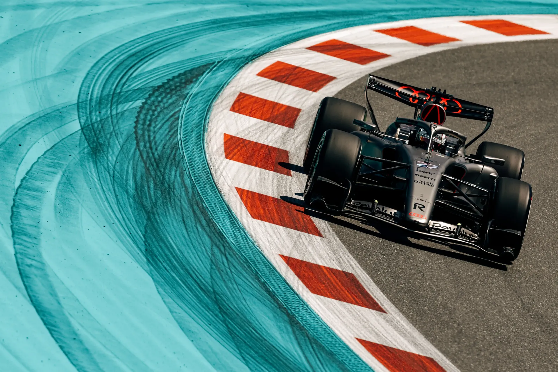 Overhead view of Audi Revolut F1® Team car number 27 driven by Nico Hulkenberg sweeping through a corner framed by Miami’s blue and orange track markings.