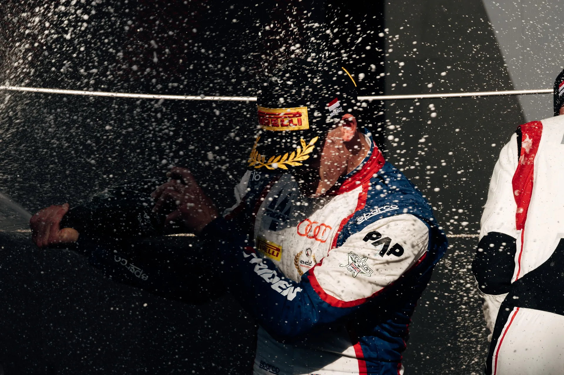 Freddie Slater celebrating with champagne on the podium in Monaco