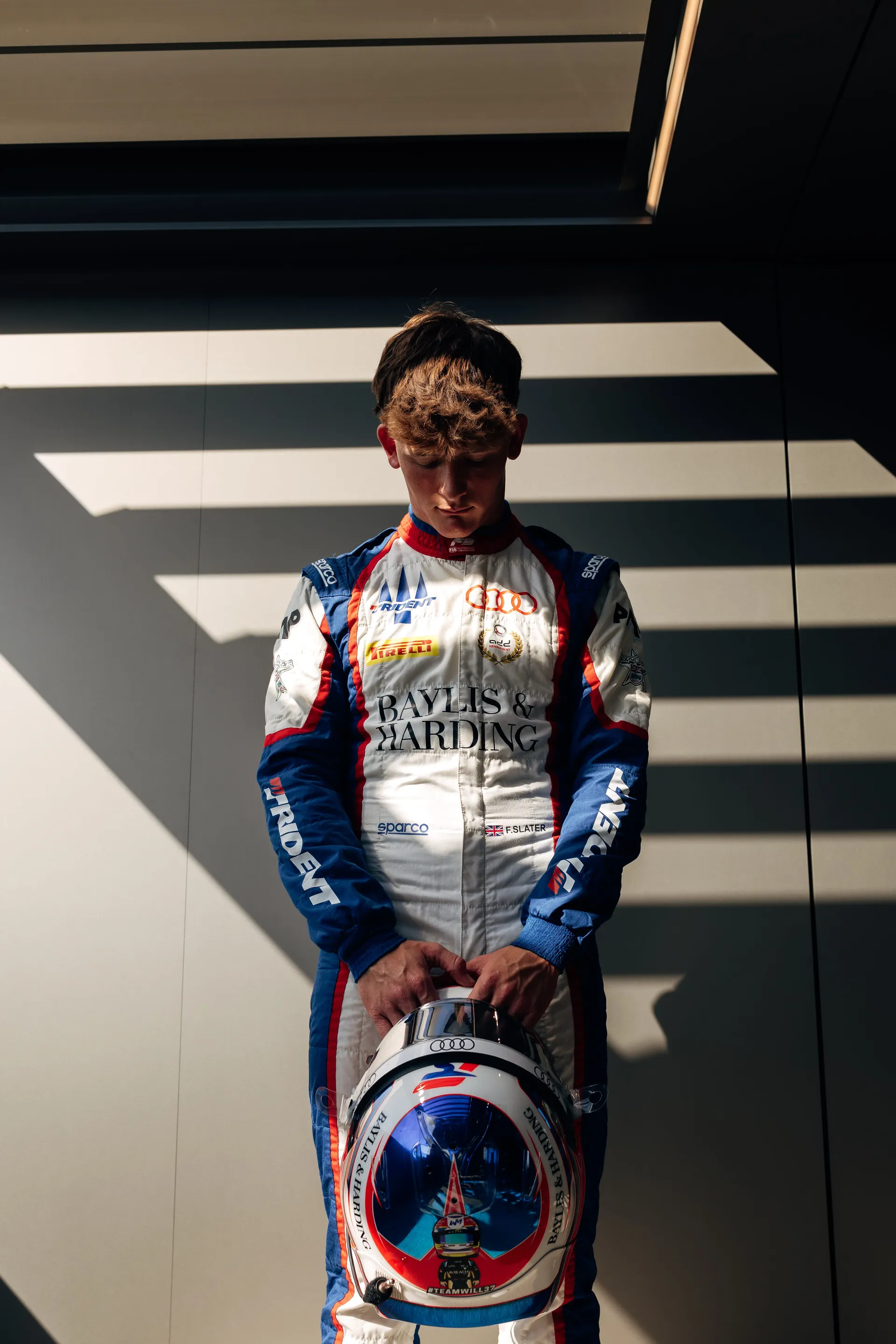 Freddie Slater looking down at his helmet, held in both hands