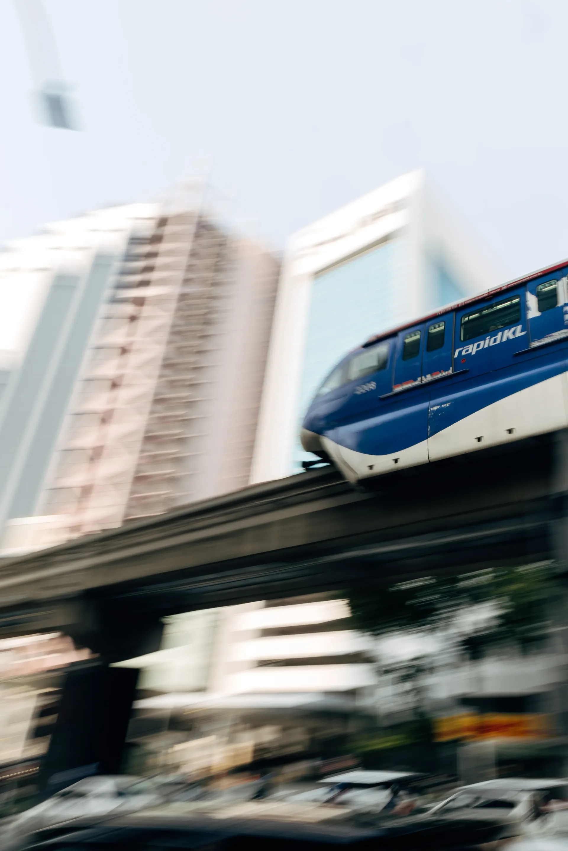 Blue rapidKL monorail on an elevated track in Kuala Lumpur, shot with motion blur