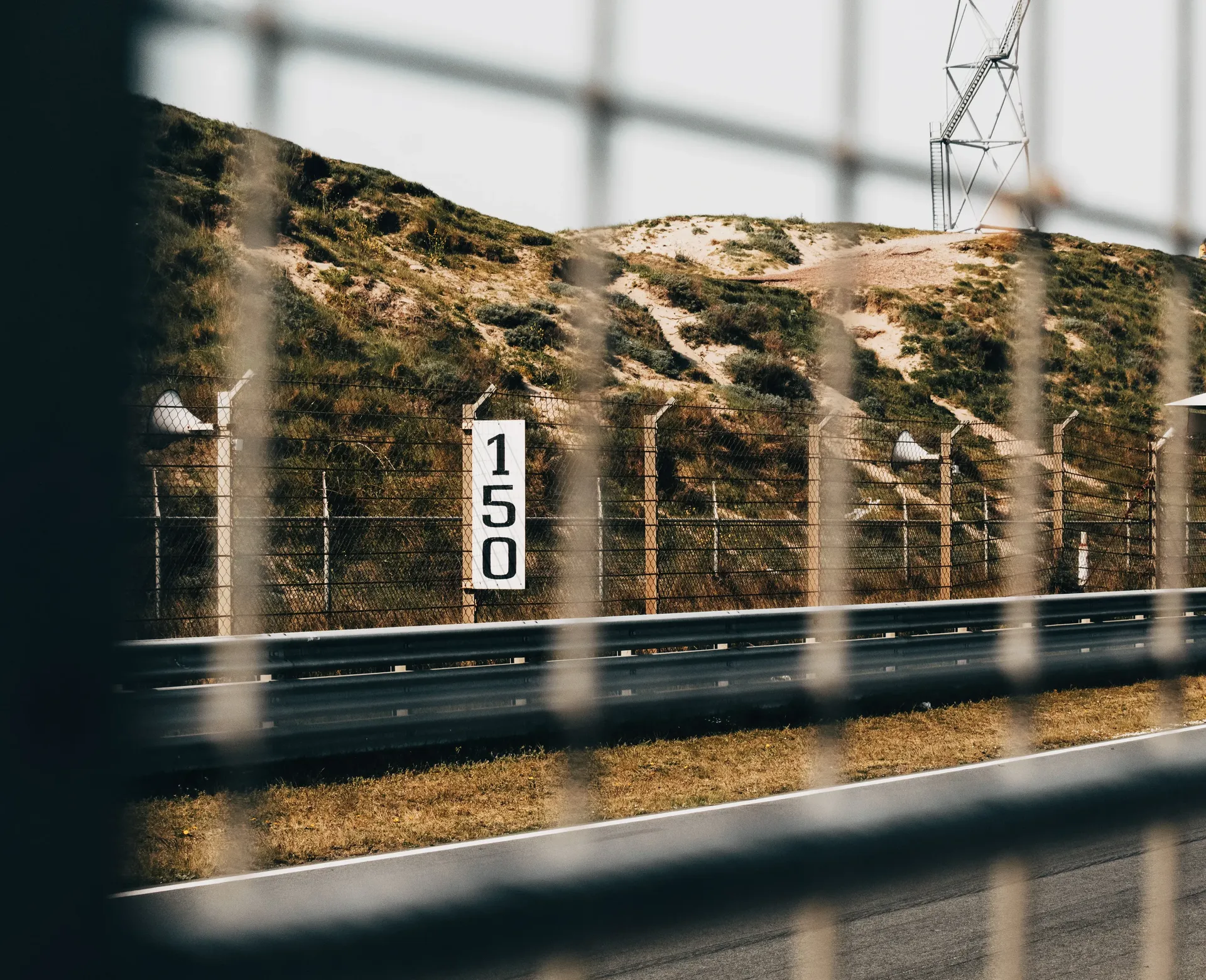 Zandvoort circuit dune fencing with 150m marker board — track detail ahead of the Audi Revolut F1 Team Dutch GP