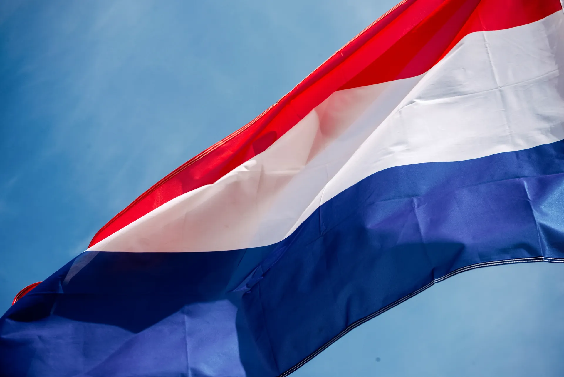 Close-up of the Dutch national flag waving against a blue sky — Audi Revolut F1 Team Dutch Grand Prix pride