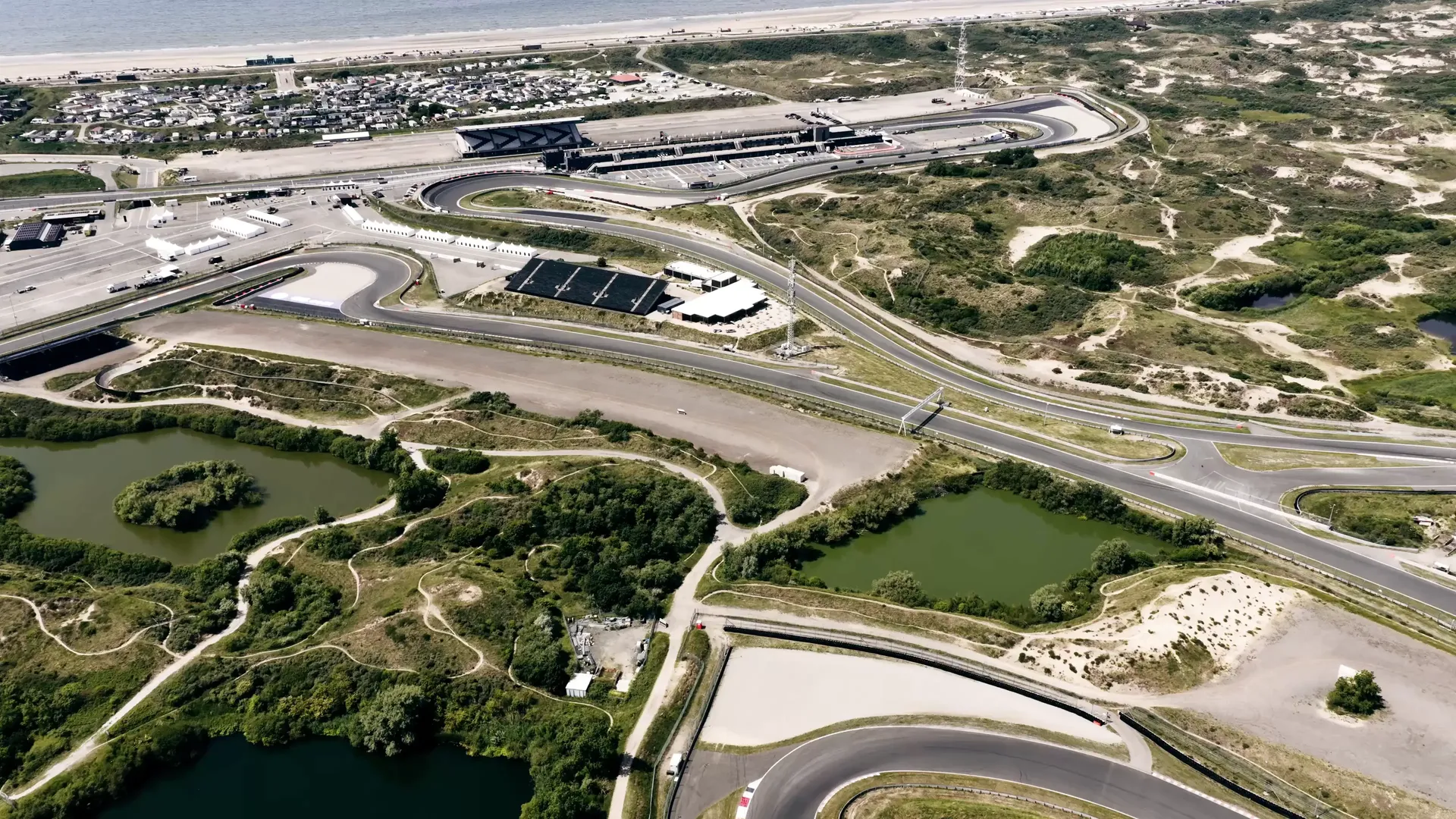 Aerial drone view of Circuit Zandvoort, showing the full Dutch Grand Prix circuit winding through the coastal dunes near the North Sea.