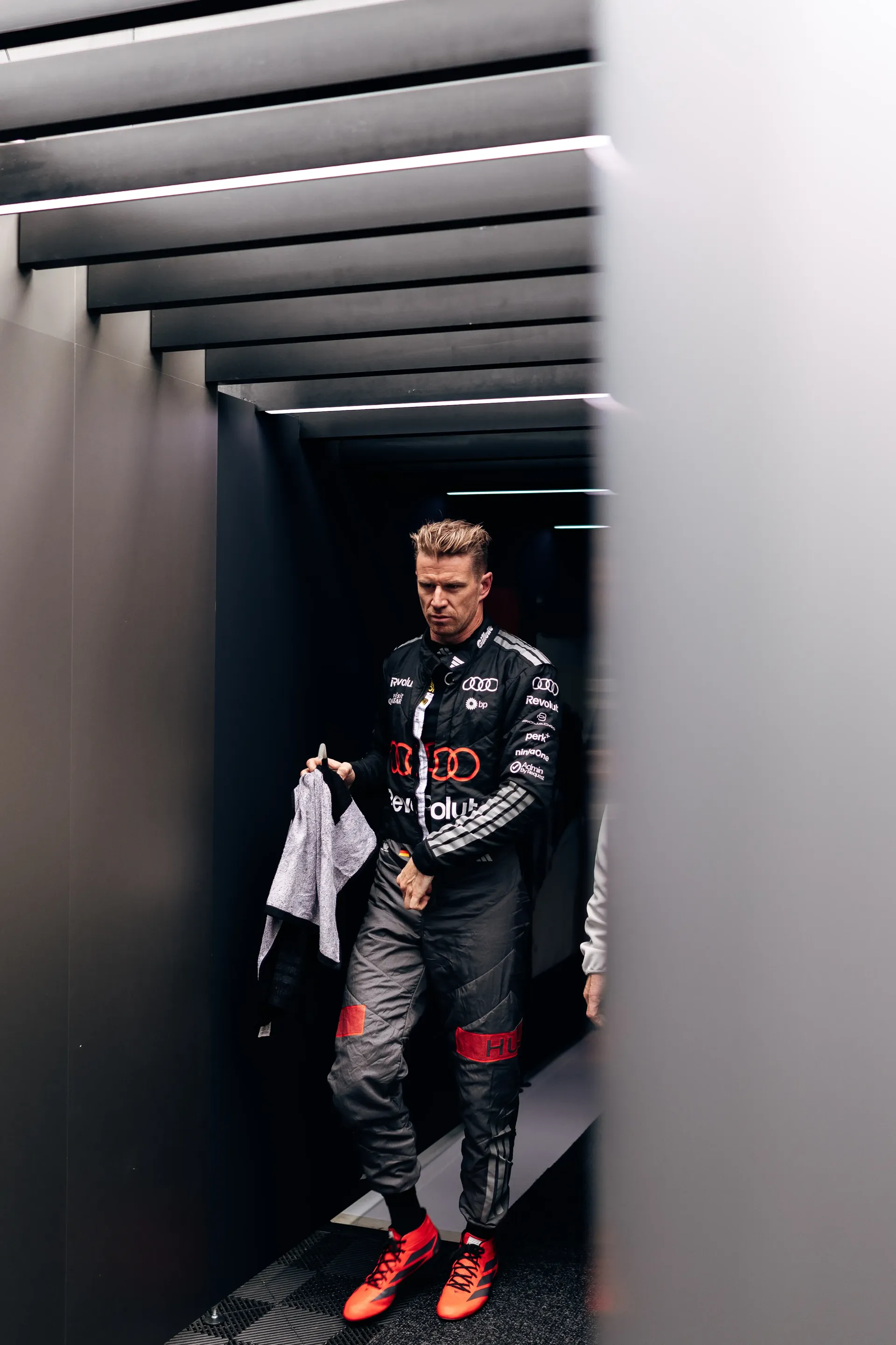 Nico Hulkenberg in his Audi Revolut F1® Team race suit walking through the garage corridor at Zandvoort