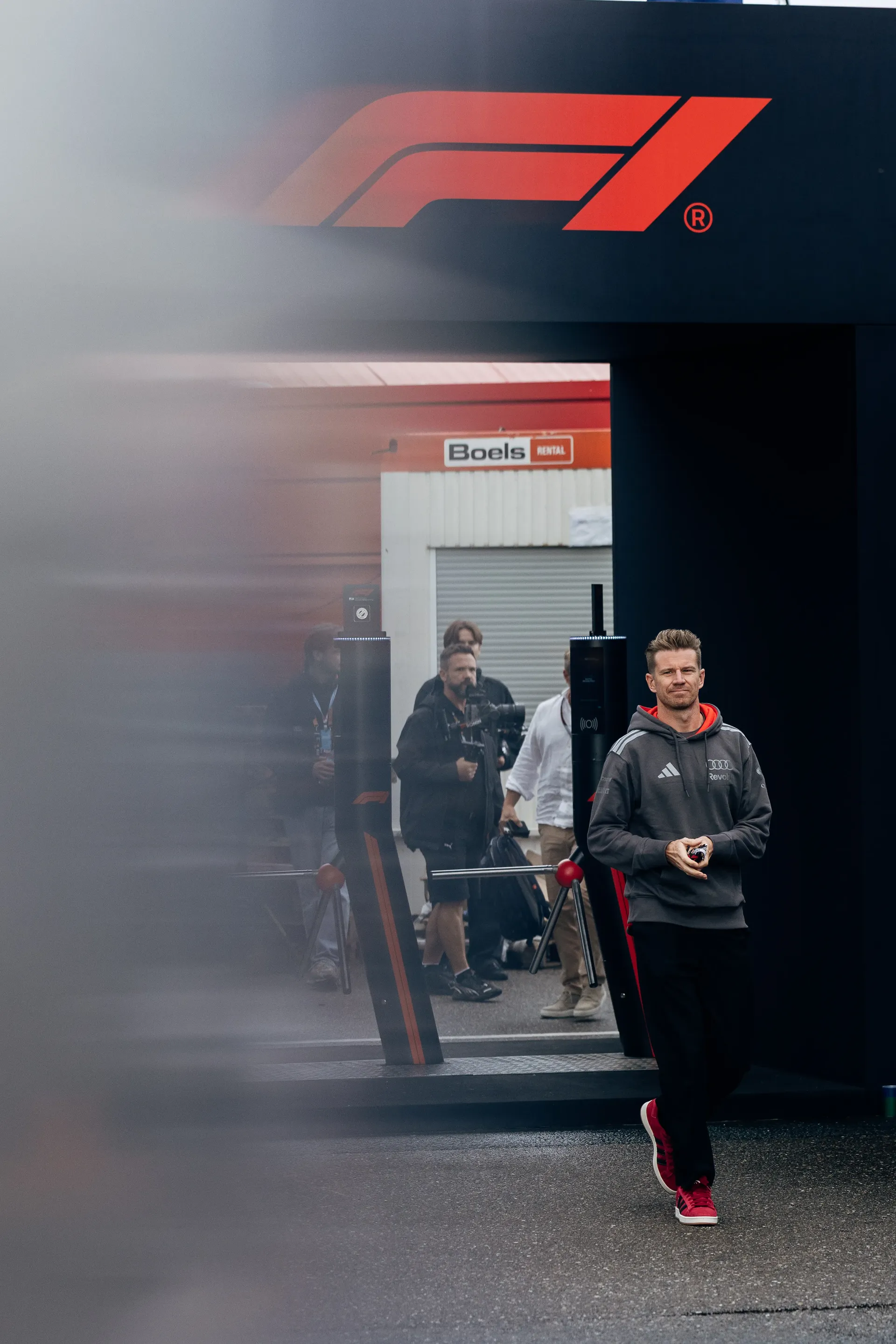 Nico Hulkenberg walking through the paddock beneath the F1® logo at Zandvoort