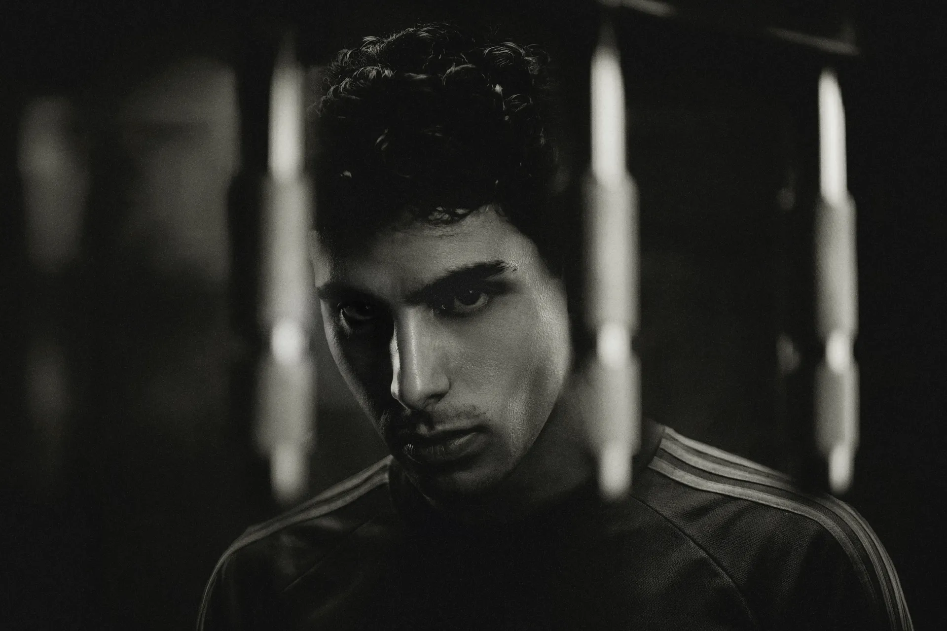 Black-and-white portrait of Gabriel Bortoleto, driver for the Audi Revolut F1® Team, with intentional motion blur and dramatic lighting creating a cinematic effect.