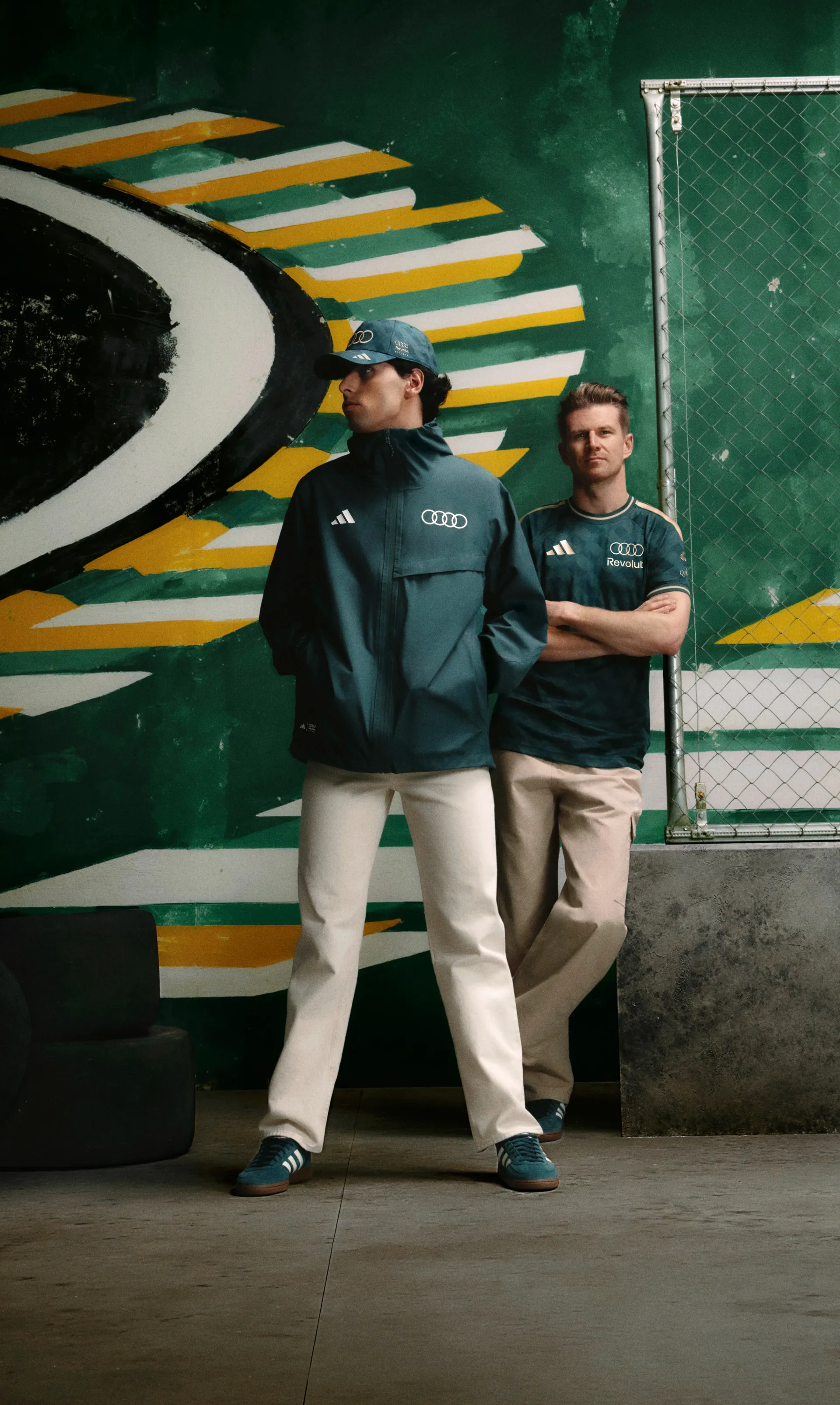 Nico Hulkenberg and Gabriel Bortoleto drivers at the Audi Revolut F1® Team side by side in front of a green and yellow mural, adidas x Audi Revolut F1® Team Sampa Soul collection