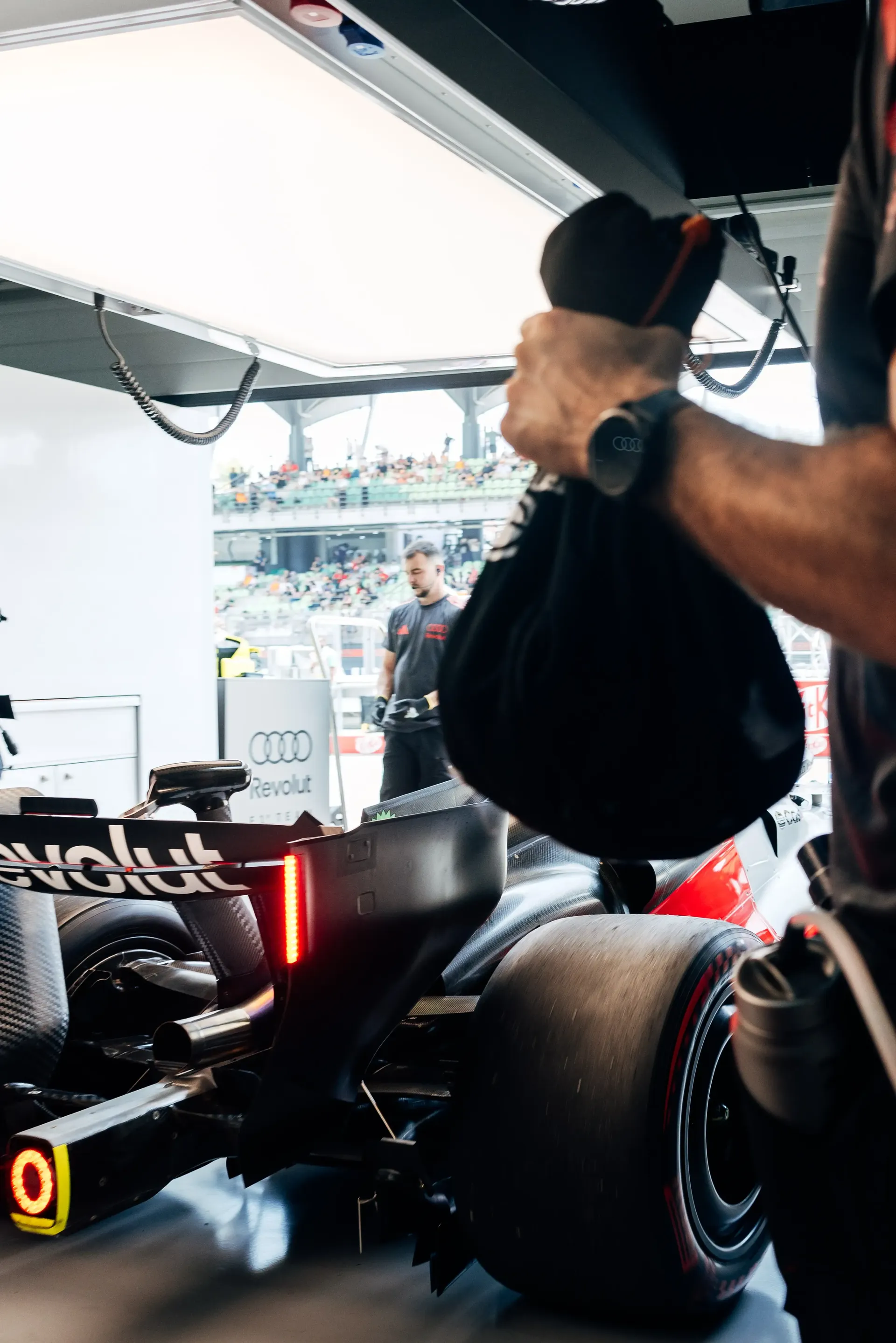 Audi Revolut F1® Team mechanic working beside the Formula 1 car in the garage.