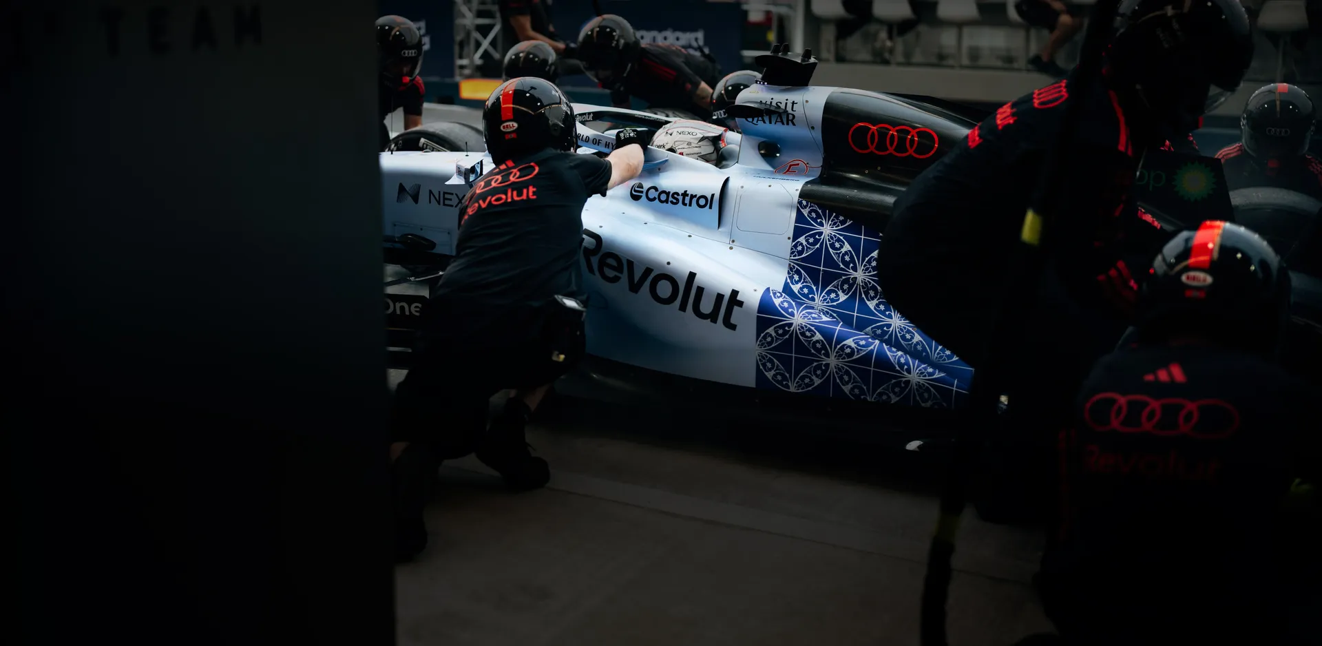 Side view of the Audi Revolut F1® Team car R26 in special Singapore Livery at the pit stop action