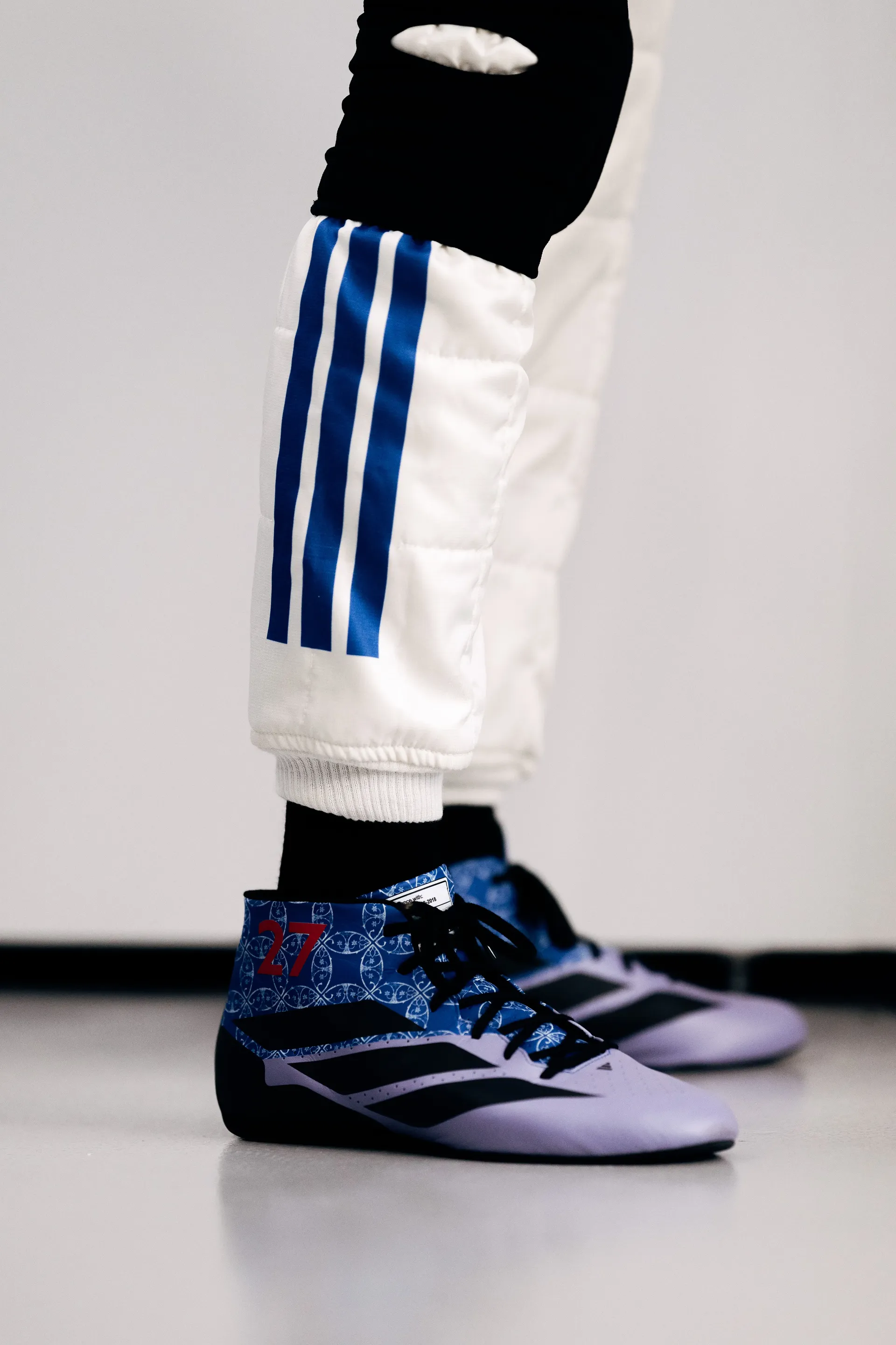 Nico Hulkenberg’s Audi Revolut F1® Team race boots with his number 27 on a blue tile pattern, below his white race suit.