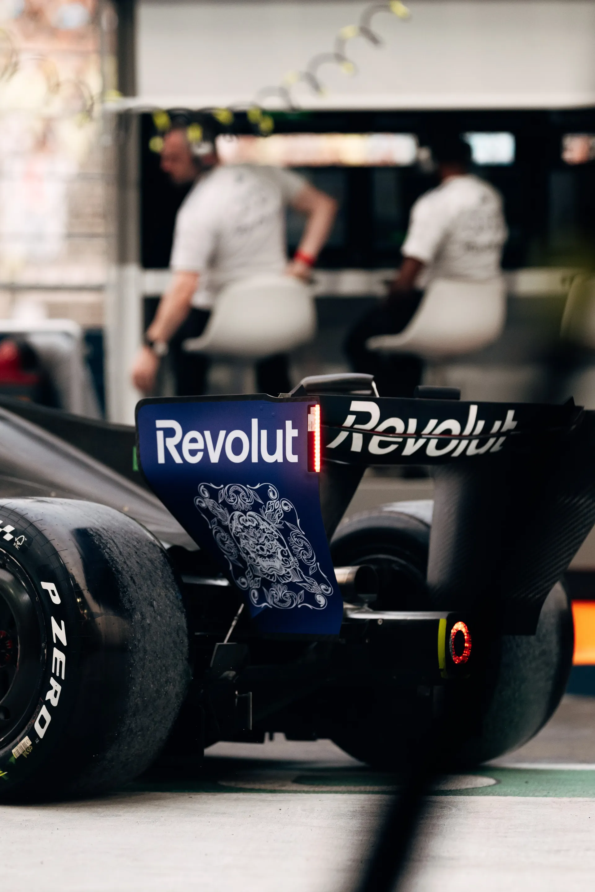 Rear of the Audi Revolut F1® Team car R26 in the pit lane, engineers on the pit wall in the background.