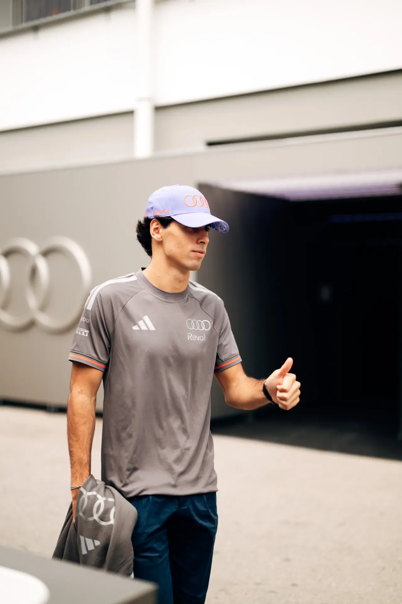 Gabriel Bortoleto of the Audi Revolut F1® Team in a lavender cap and grey team shirt gives a thumbs up in Singapore