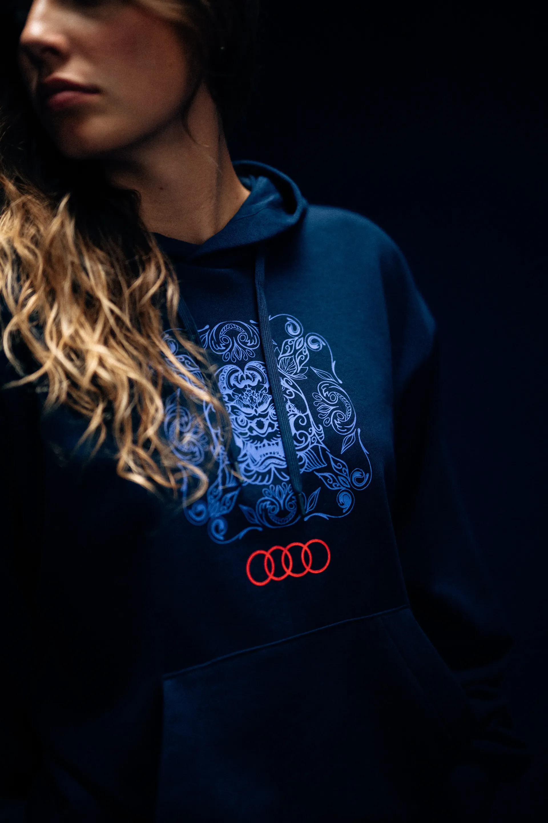 Close-up of an Audi Revolut F1® Team hoodie with tile-pattern print and Audi rings on the chest