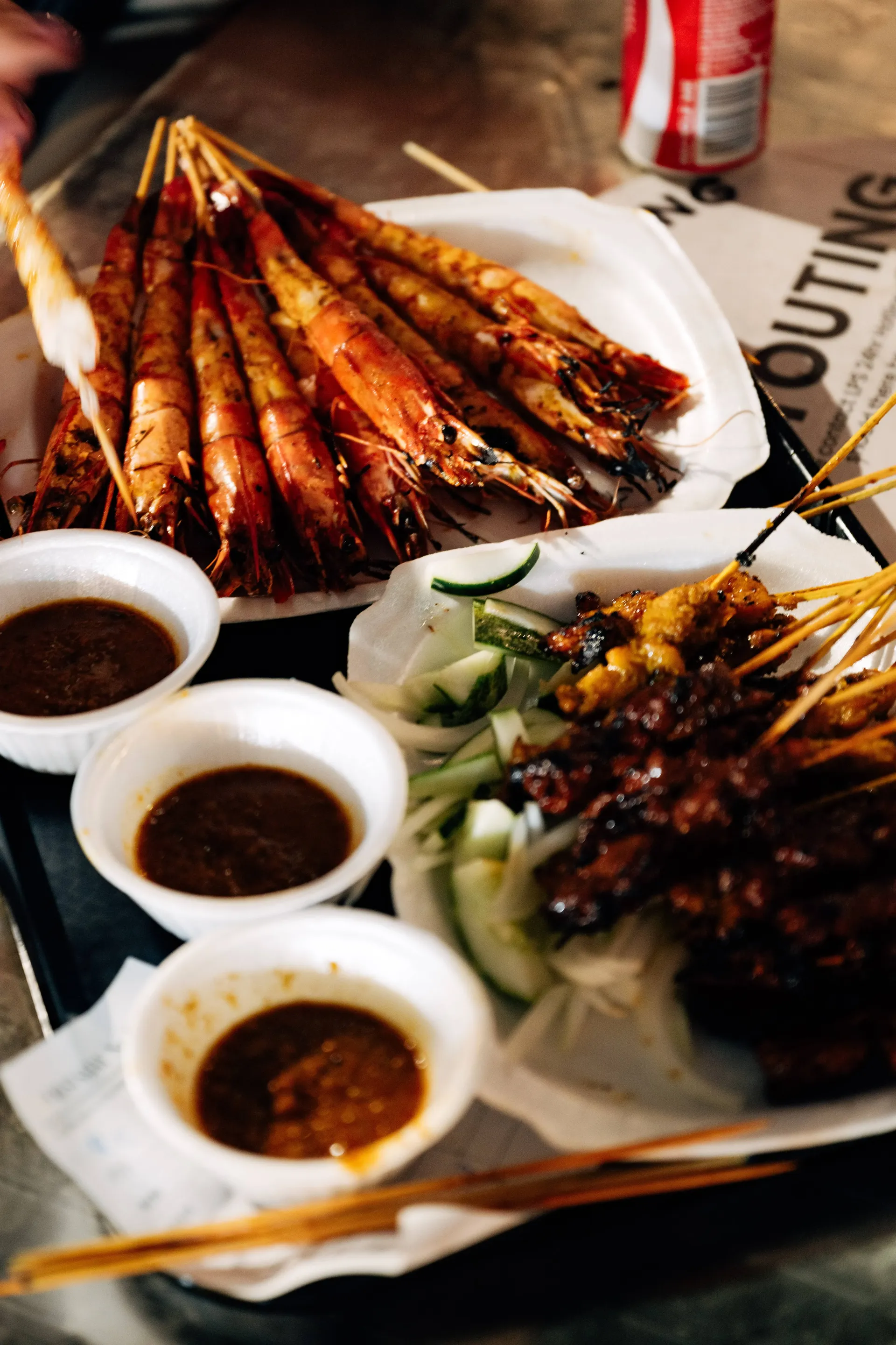 Grilled prawn skewers and satay with peanut sauce, cucumber and onion at Lau Pa Sat in Singapore