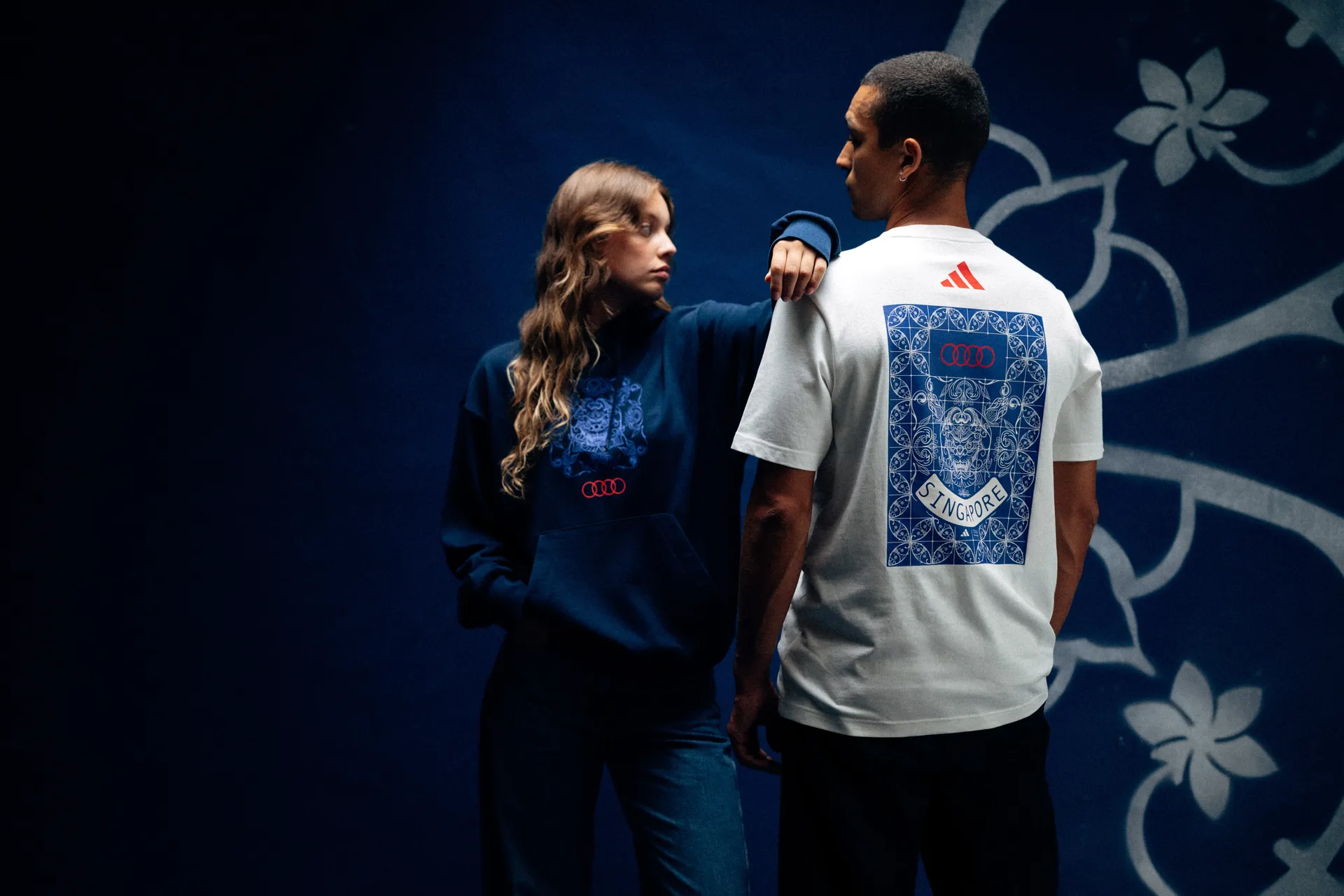 Models standing in allover tile-print Audi Revolut F1® Team outfits