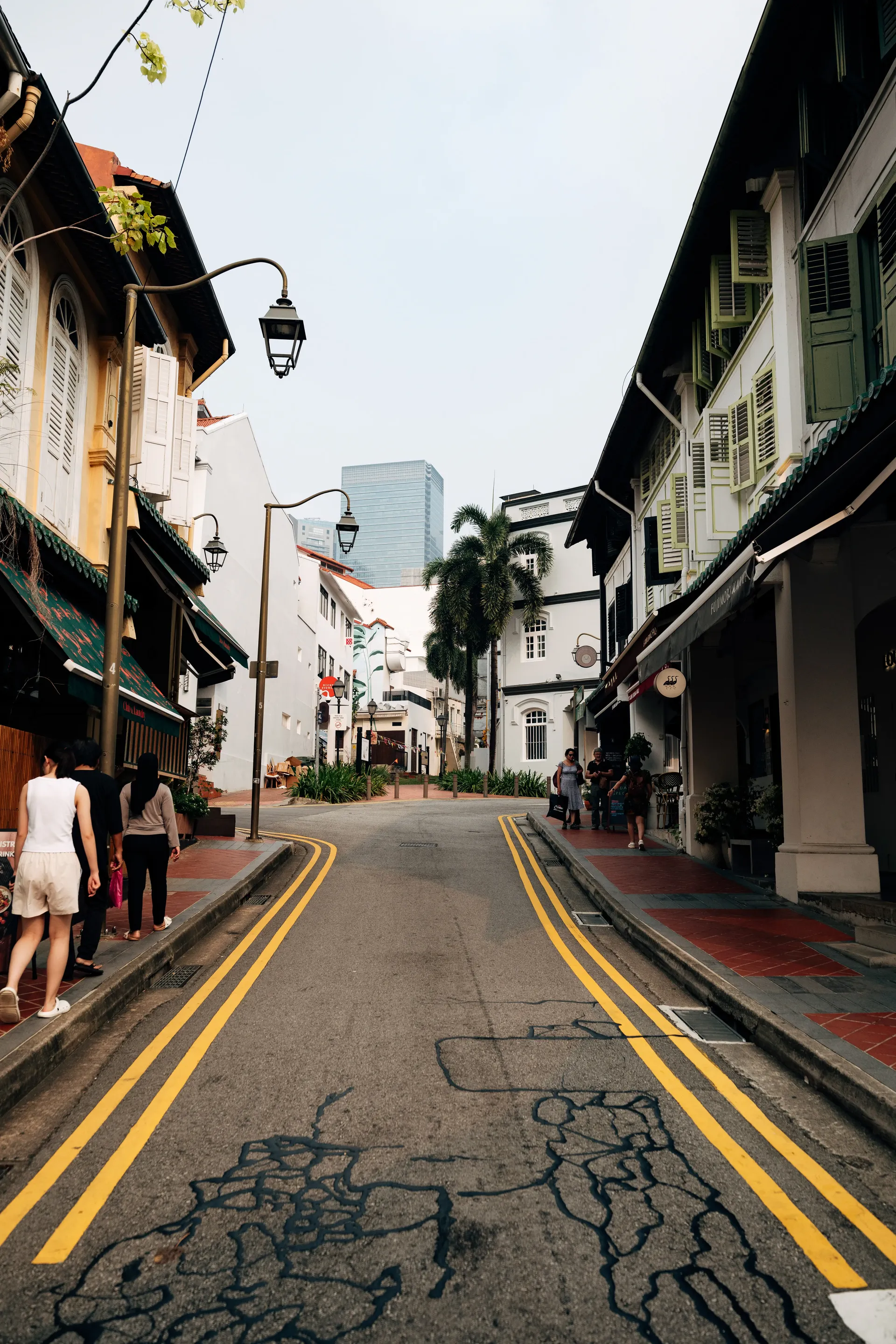 Street in Singapore with shophouses and yellow road markings