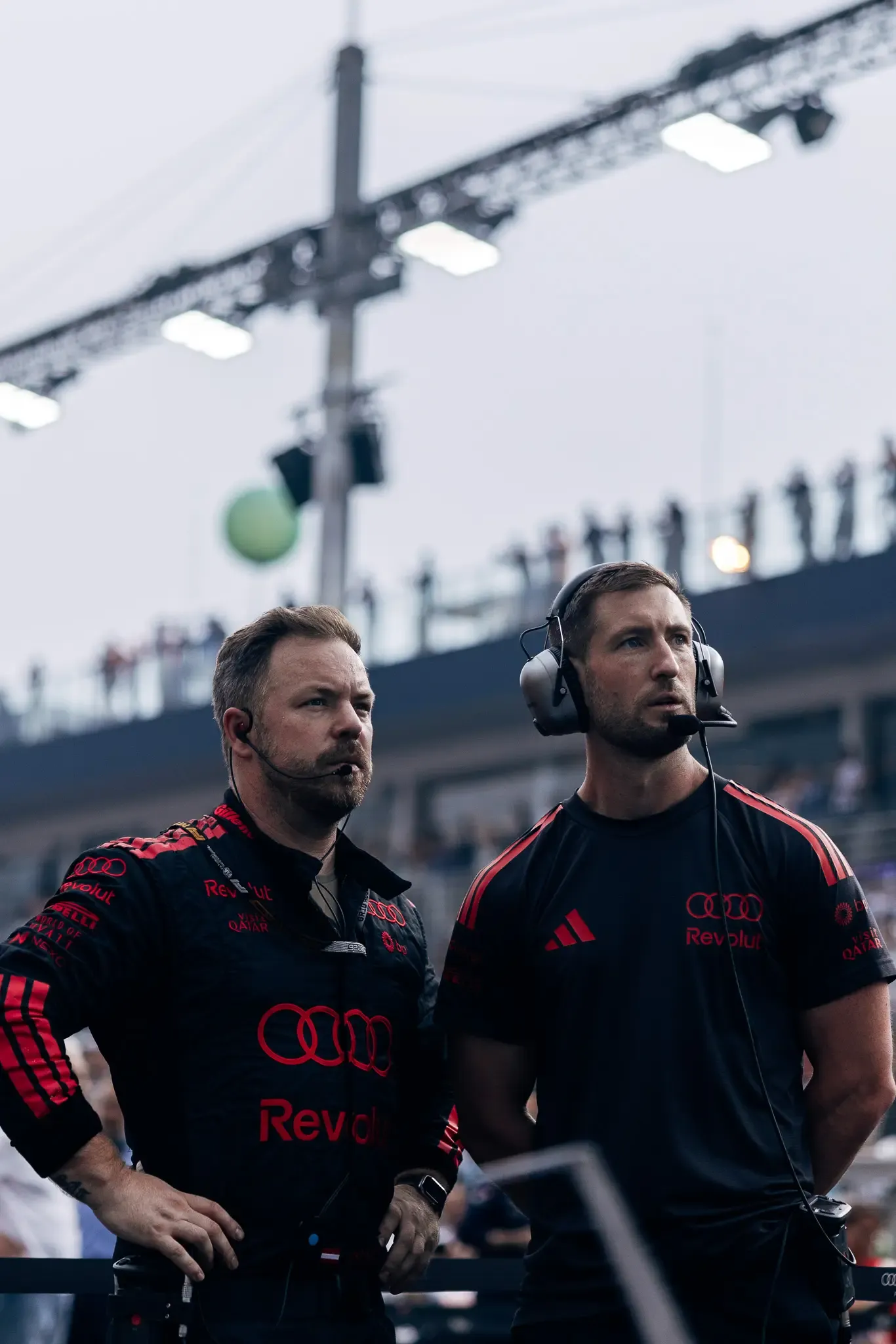 Two Audi Revolut F1® Team mechanics with headsets on the grid.