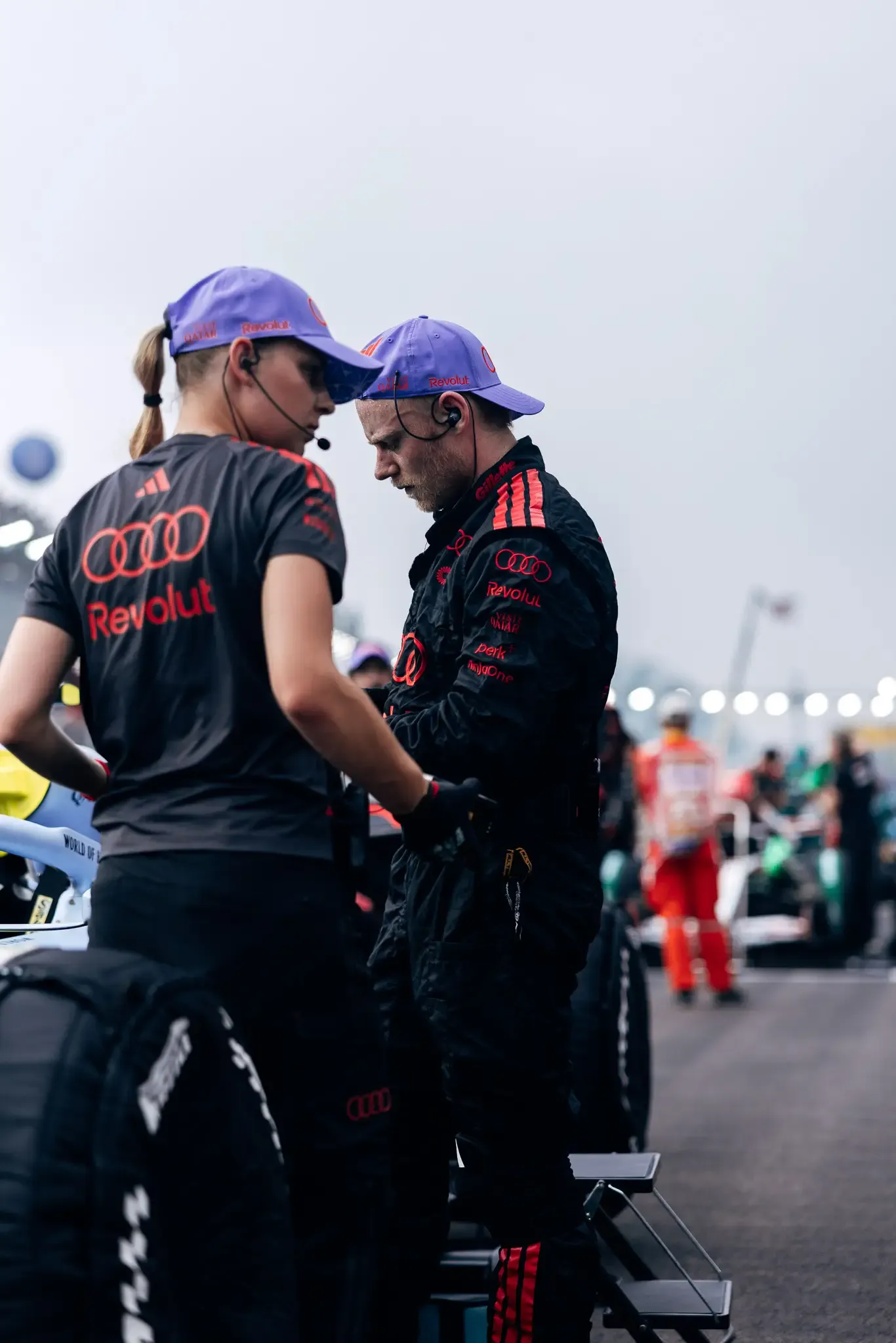 Two Audi Revolut F1® Team mechanics talking on the grid.