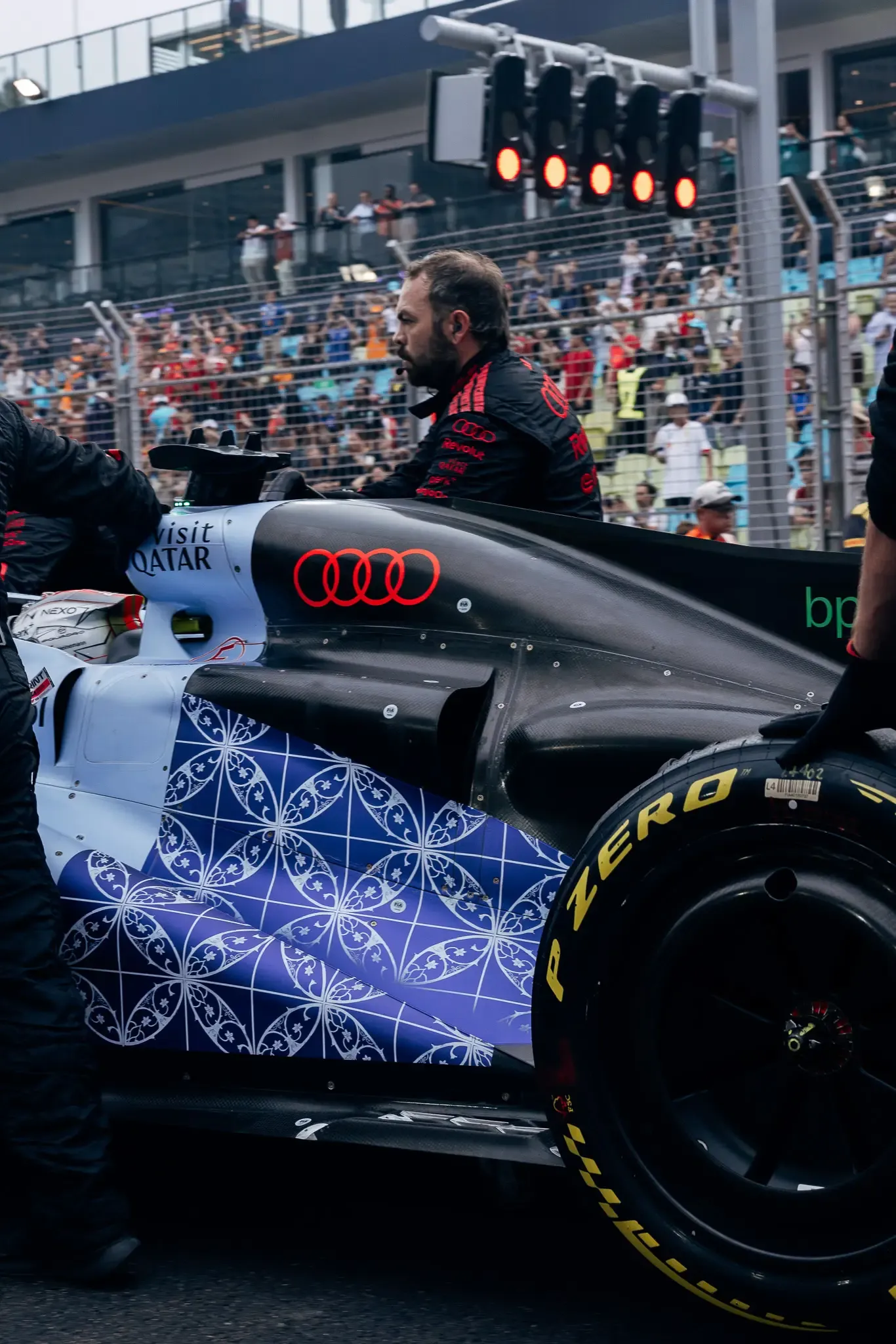 Audi Revolut F1® Team mechanic beside the car on the grid.