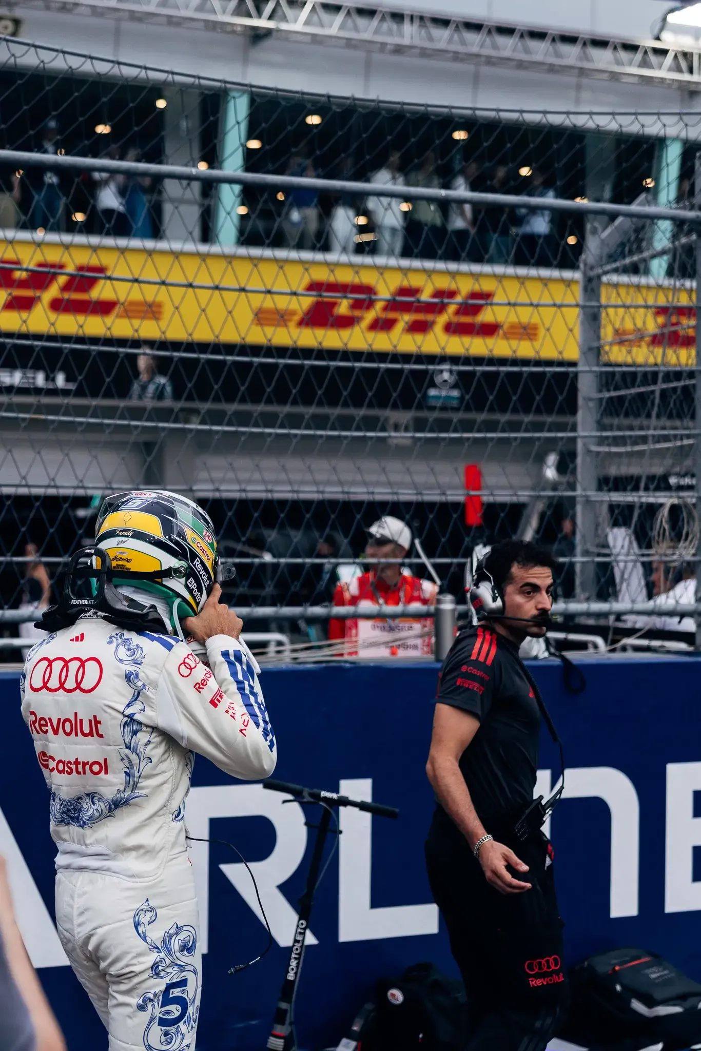Audi Revolut F1® Team driver Gabriel Bortoleto walking along the pit wall.