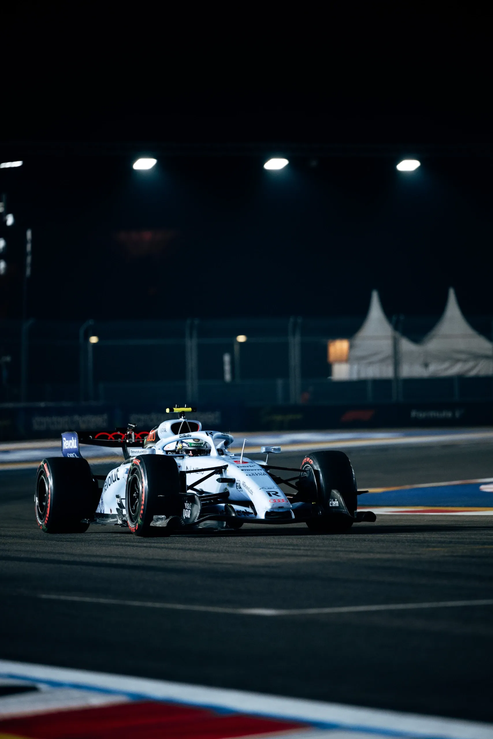 White Singapore special livery car of the Audi Revolut F1® Team cornering on a floodlit night circuit in Singapore