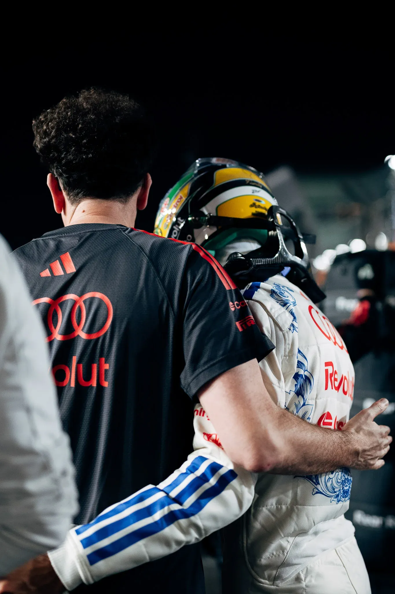 Audi Revolut F1® Team principal Mattia Binotto embraces driverGabriel Bortoleto, helmet on, on the grid before the race.