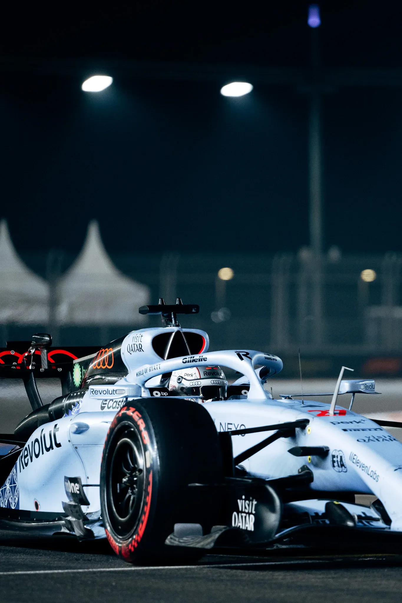 Audi Revolut F1® Team car R26 on track at night at the Singapore Grand Prix, lit by trackside floodlights.