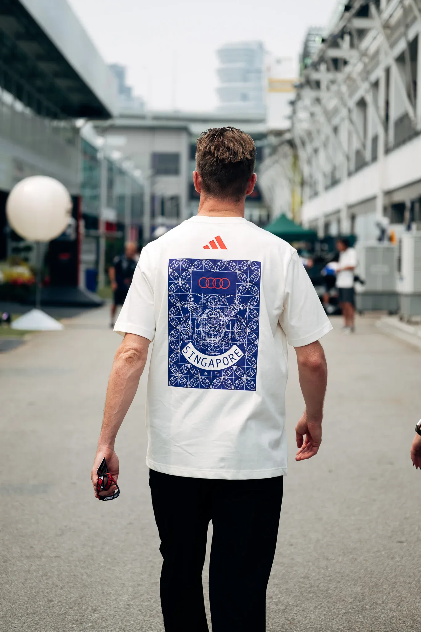 Nico Hulkenberg driver of the Audi Revolut F1® Team, walking through Singapore in a white adidas T-shirt.