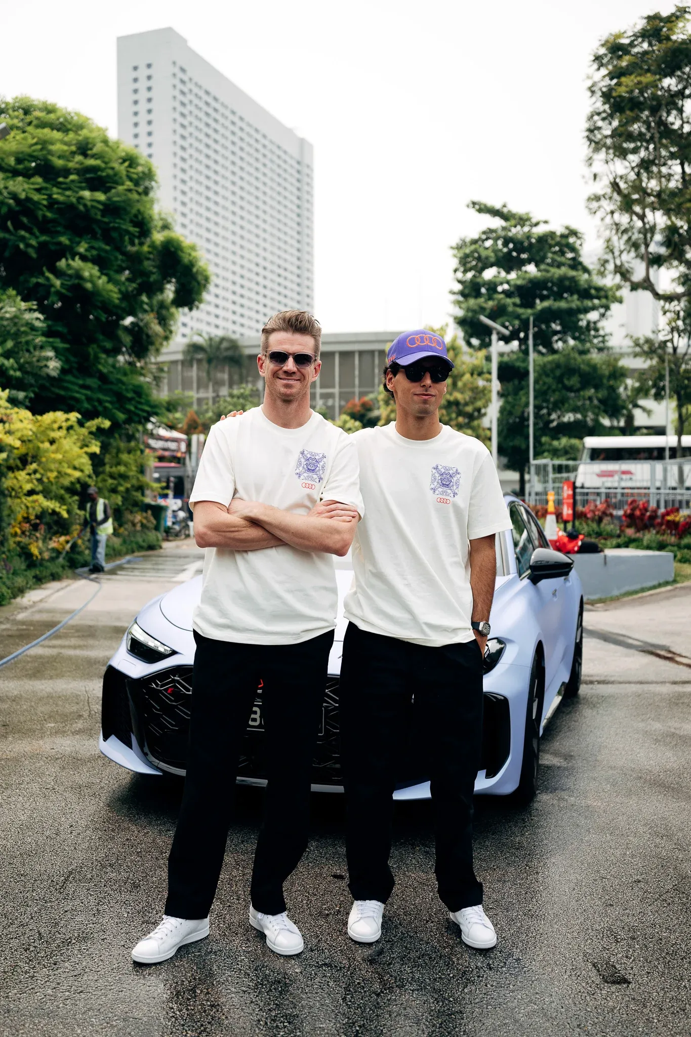 Nico Hulkenberg and Gabriel Bortoleto, drivers of the Audi Revolut F1® Team, standing together beside a car in Singapore.