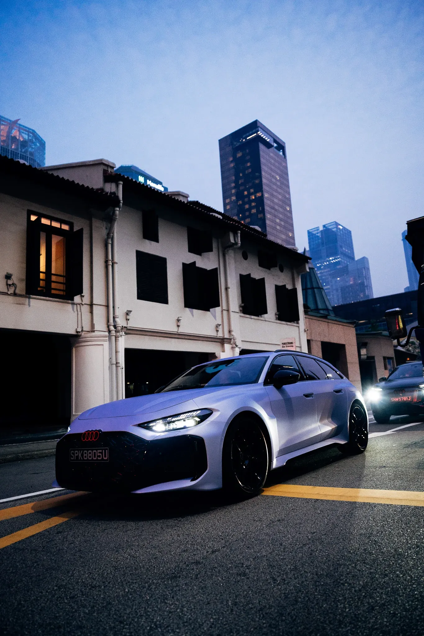 Titanium Blue Audio RS 5 car parked on a Singapore street with skyscrapers in the background.