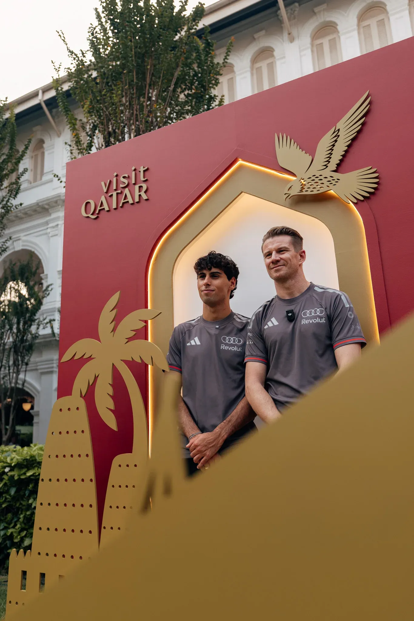 Audi Revolut F1® Team drivers Gabriel Bortoleto and Nico Hulkenberg posing inside a Singapore-themed event installation.
