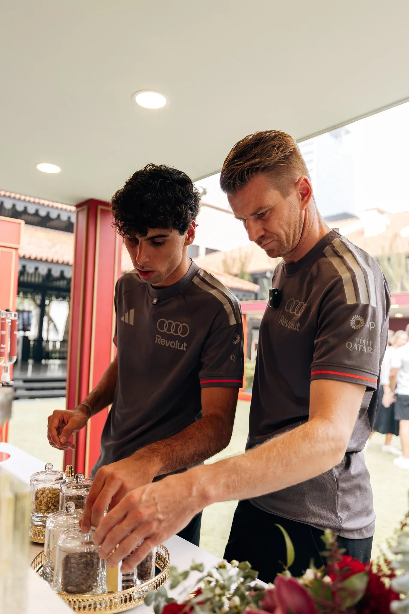 Audi Revolut F1® Team drivers Gabriel Bortoleto and Nico Hulkenberg preparing food together during an event.